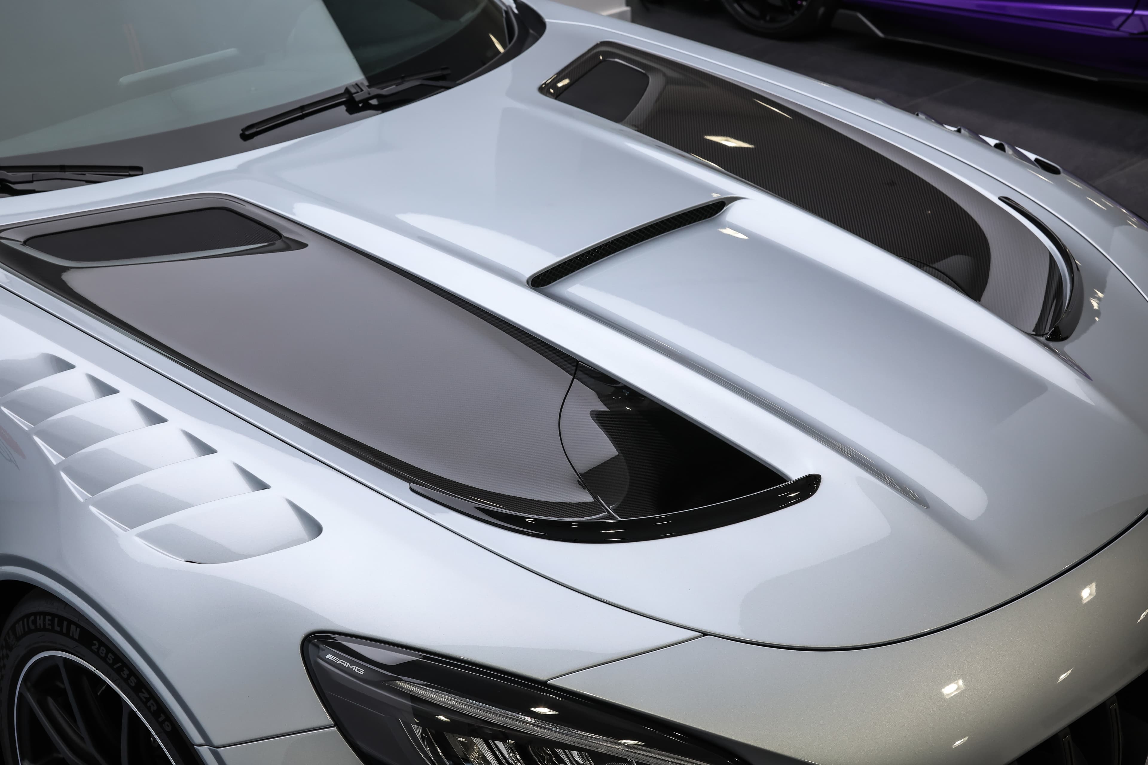  Plongez dans les détails des entrées d'air sur le capot avant de notre AMG Black Series, conçues pour optimiser la performance et le refroidissement, alliant fonctionnalité et esthétique audacieuse. Une œuvre d'ingénierie disponible dans notre showroom à Monaco.
