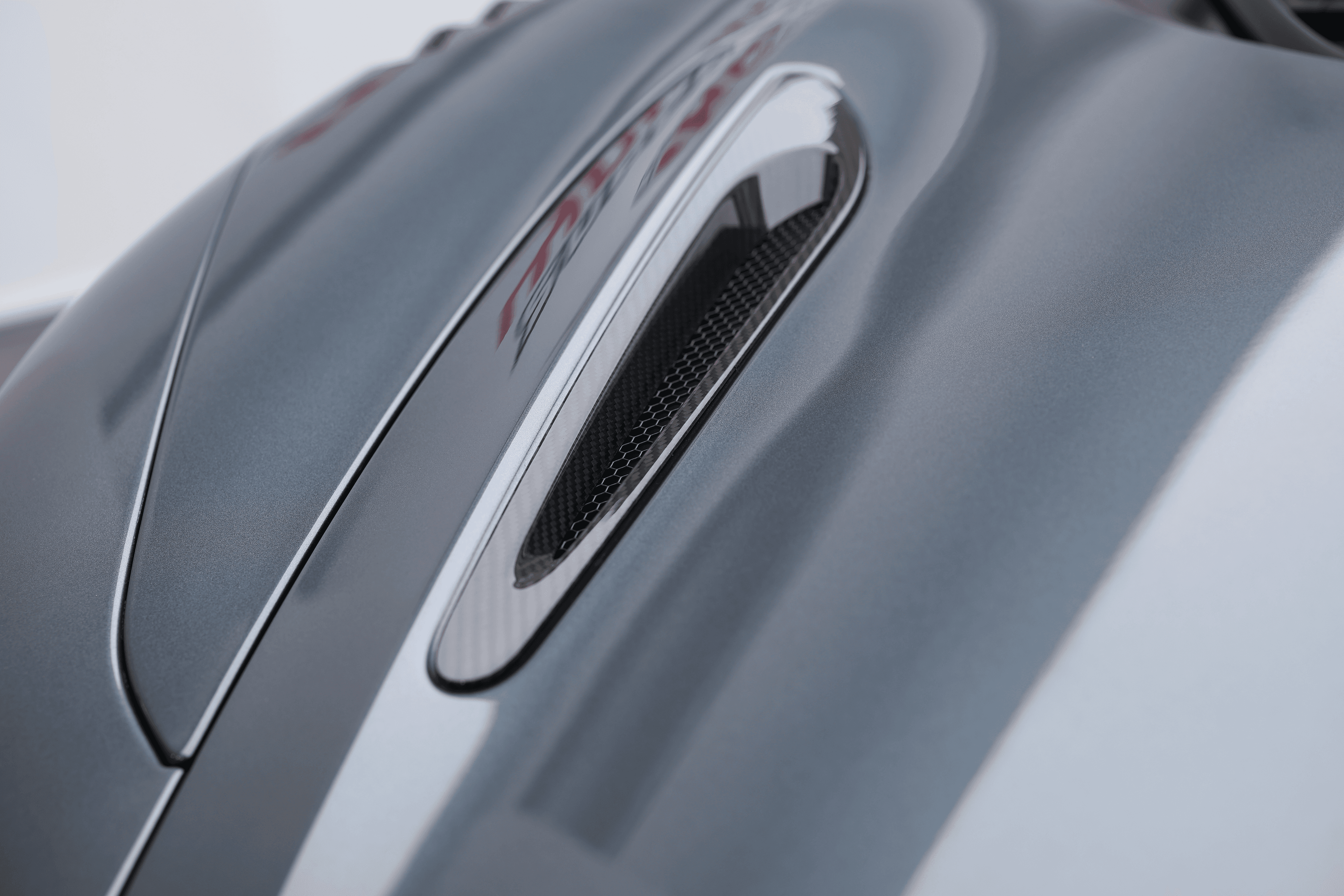 L'image montre les évents d'aération sur le capot de la McLaren 765LT, mettant en avant leur design fonctionnel et esthétique, qui contribue à la gestion thermique et à l'aérodynamisme du véhicule tout en ajoutant une touche sportive.