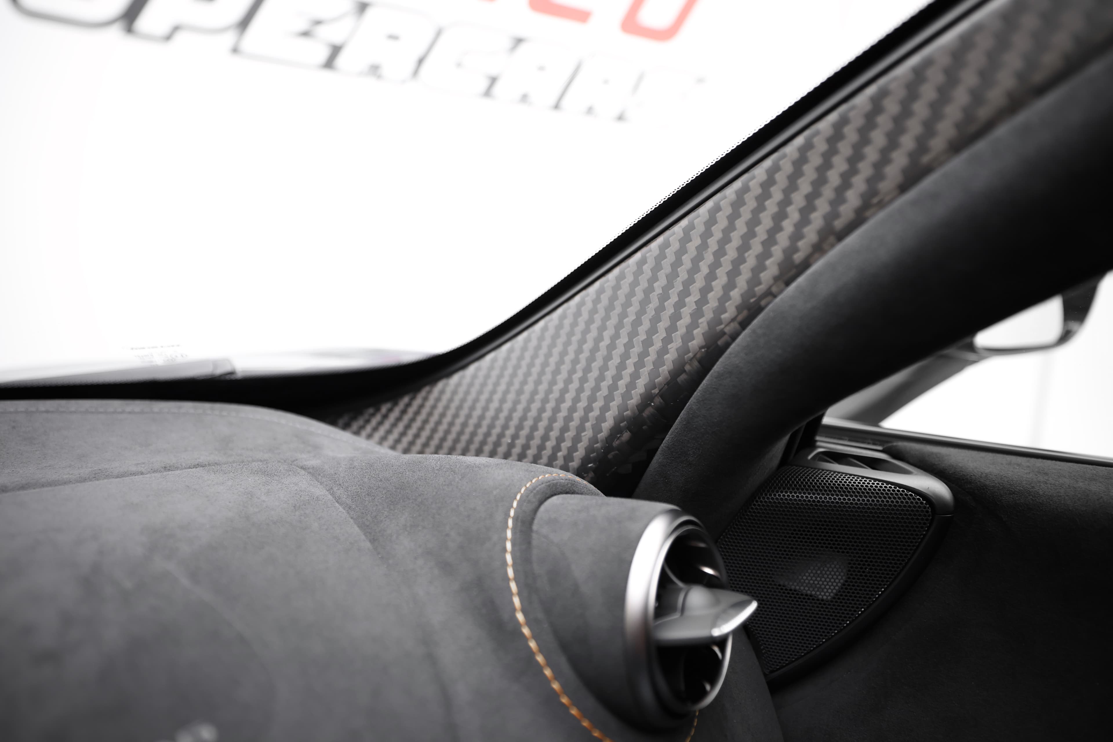 L'image montre l'intérieur d'un véhicule avec des montants en fibre de carbone, mettant en avant le design élégant et sportif. Ce matériau léger et résistant contribue non seulement à l'esthétique, mais aussi à la performance globale, en allégeant la structure du véhicule tout en ajoutant une touche de sophistication.
