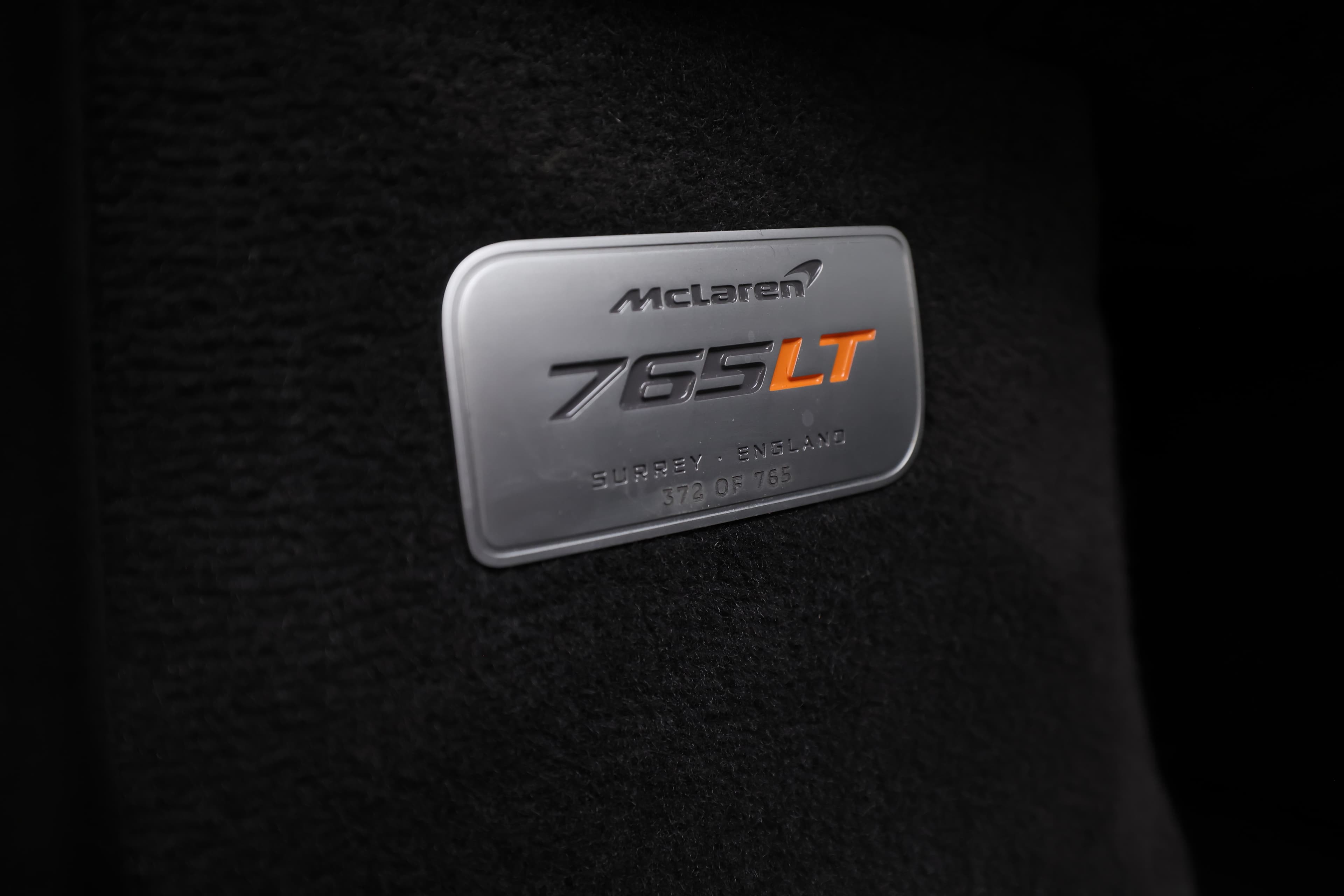 L'image montre une plaque intérieure indiquant la marque et le modèle d'un véhicule. Cette plaque est souvent située sur le tableau de bord ou près de la porte du conducteur. Elle sert à identifier le véhicule et peut également inclure des informations supplémentaires comme le numéro de série ou des données techniques.