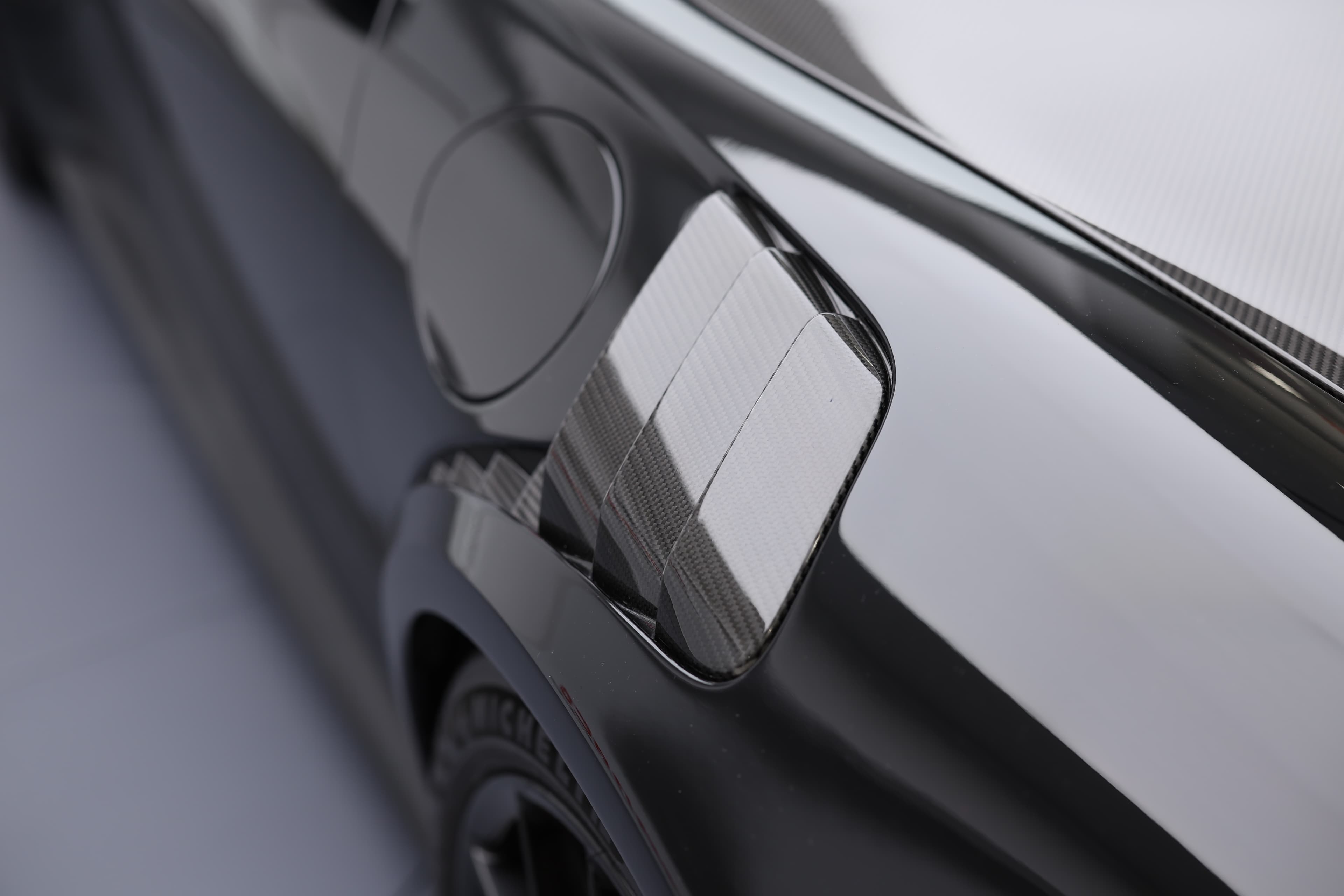 À vendre, Porsche 911 GT2 RS noire, vue des entrées d'air pour refroidissement des freins et pneus, design fonctionnel, performance optimisée, supercar de luxe, Monaco, détails sportifs