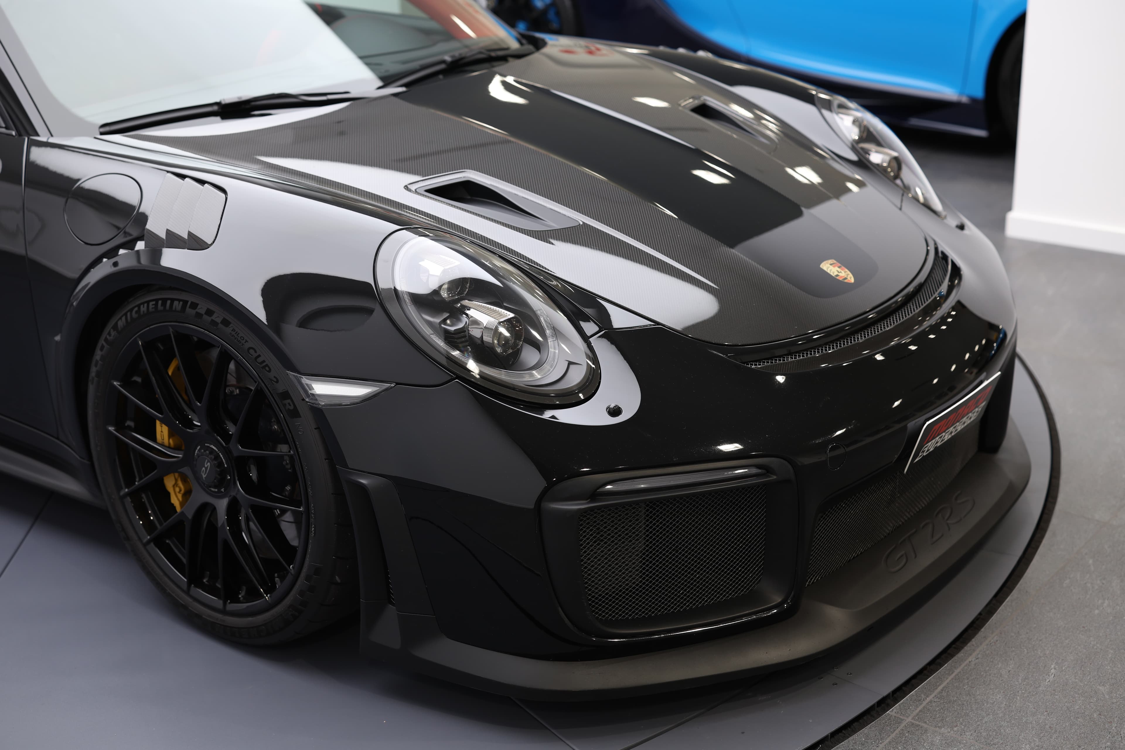 À vendre, partie avant extérieure de la Porsche 911 GT2 RS noire, design agressif, lignes aérodynamiques, éléments sportifs distinctifs, supercar de luxe, jardin à Monaco, esthétique raffinée