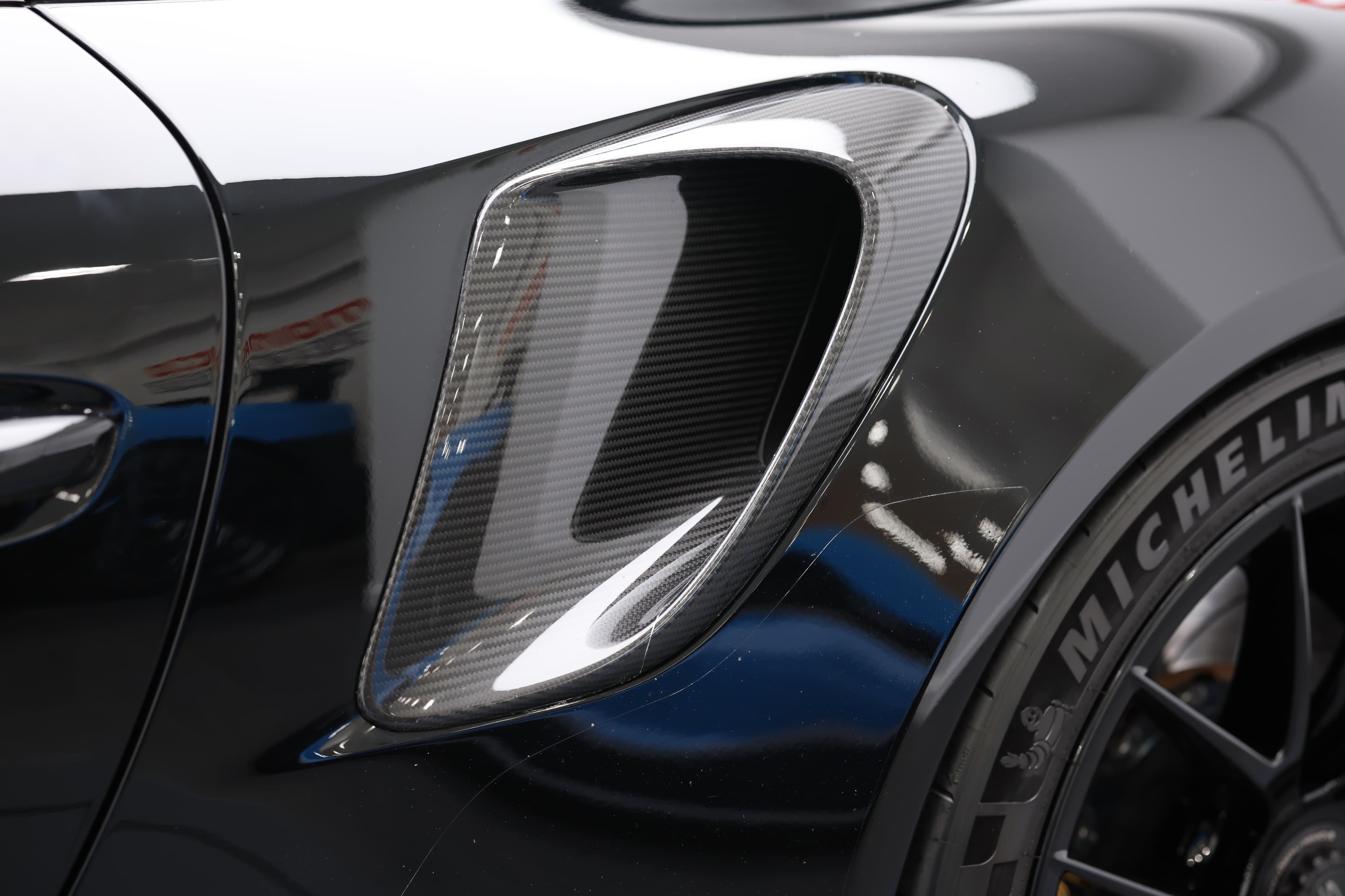 Photo de l'entrée d'air de la Porsche 911 GT2 RS noire, soulignant son design fonctionnel pour un refroidissement optimal et une performance accrue.