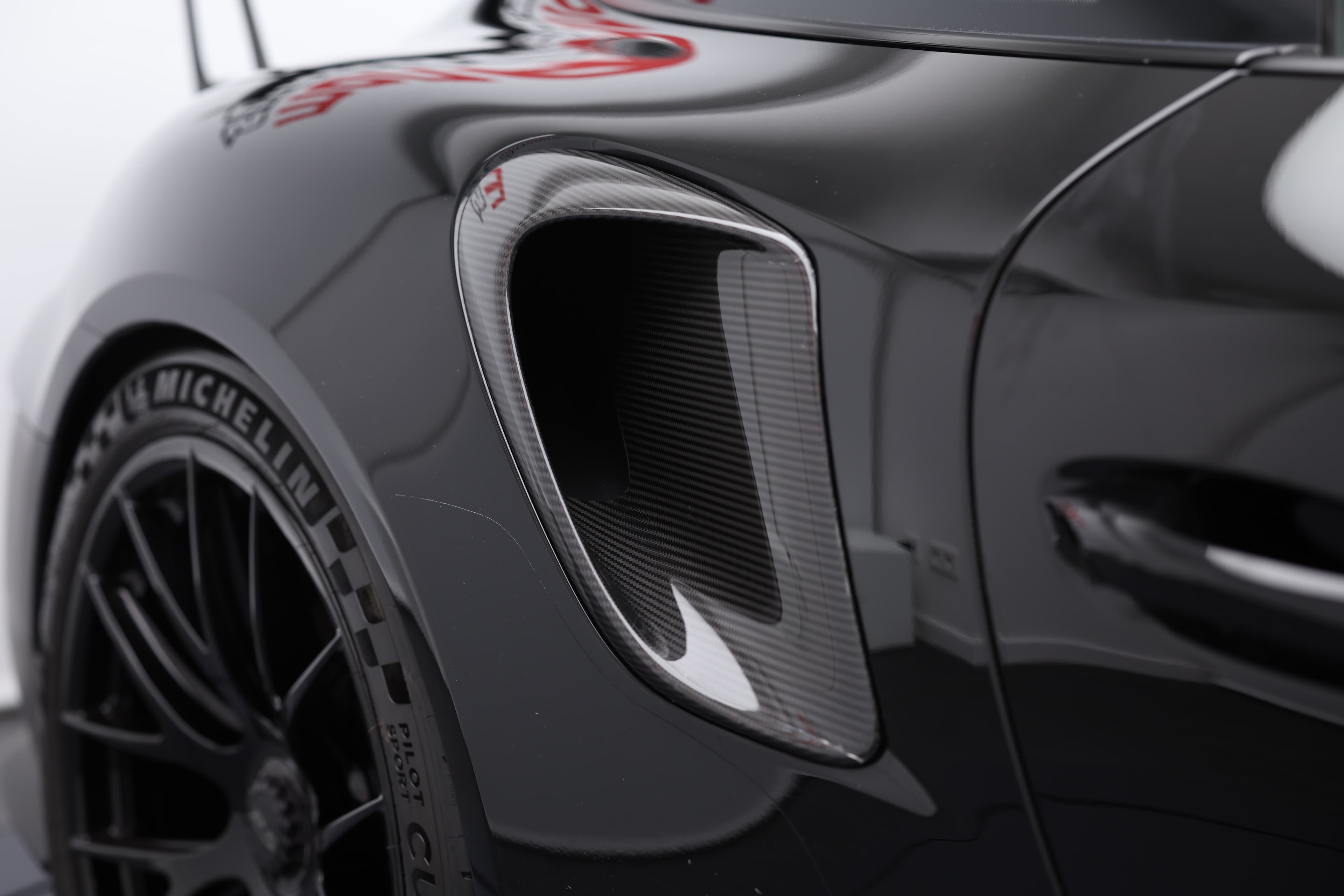 Photo de l'entrée d'air de la Porsche 911 GT2 RS noire, soulignant son design fonctionnel pour un refroidissement optimal et une performance accrue.