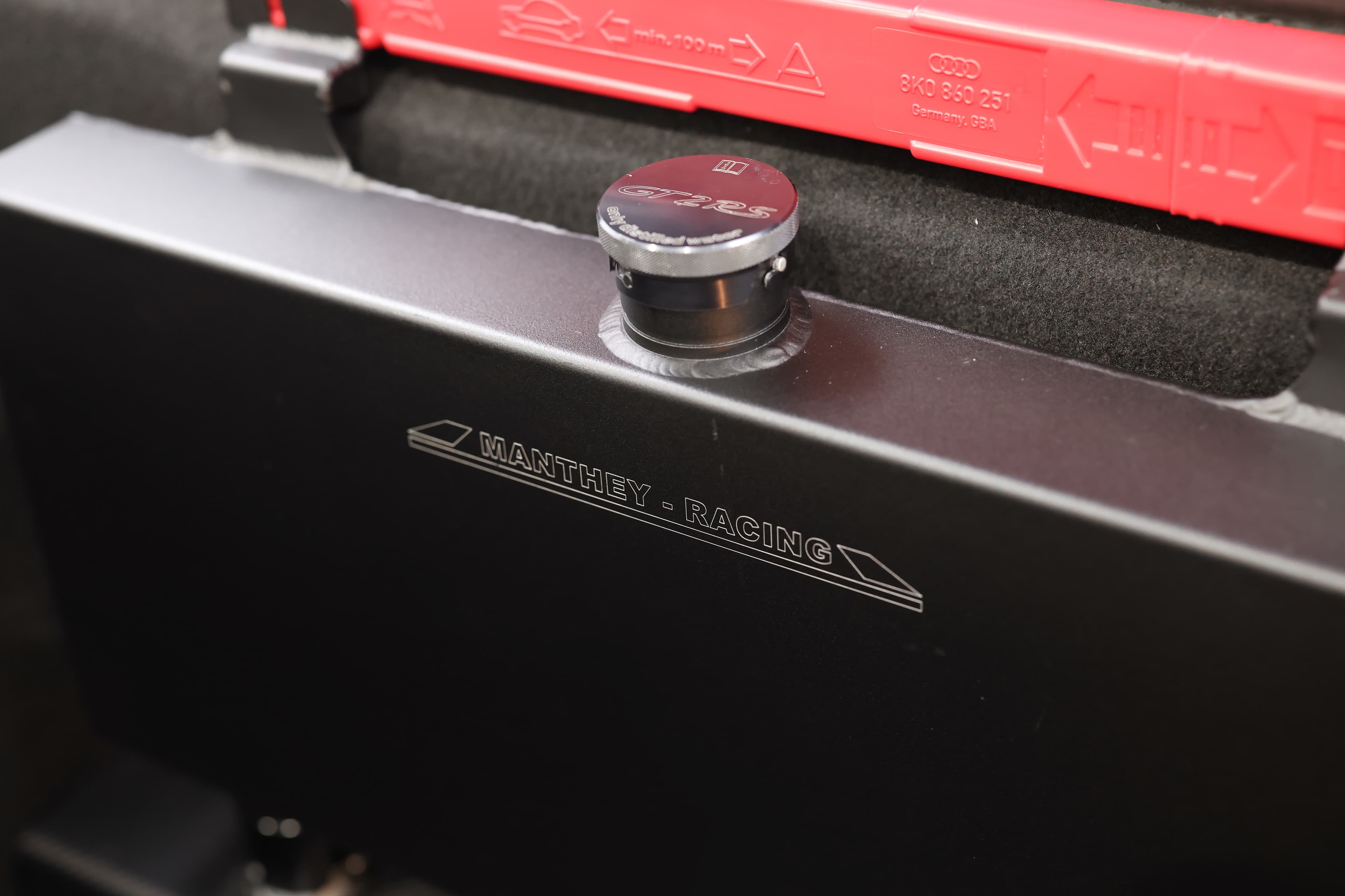 Photo du radiateur d'eau Manthey Racing de la Porsche 911 GT2 RS noire, conçu pour assurer un refroidissement optimal du moteur, améliorant ainsi la performance et la fiabilité lors de la conduite sur circuit