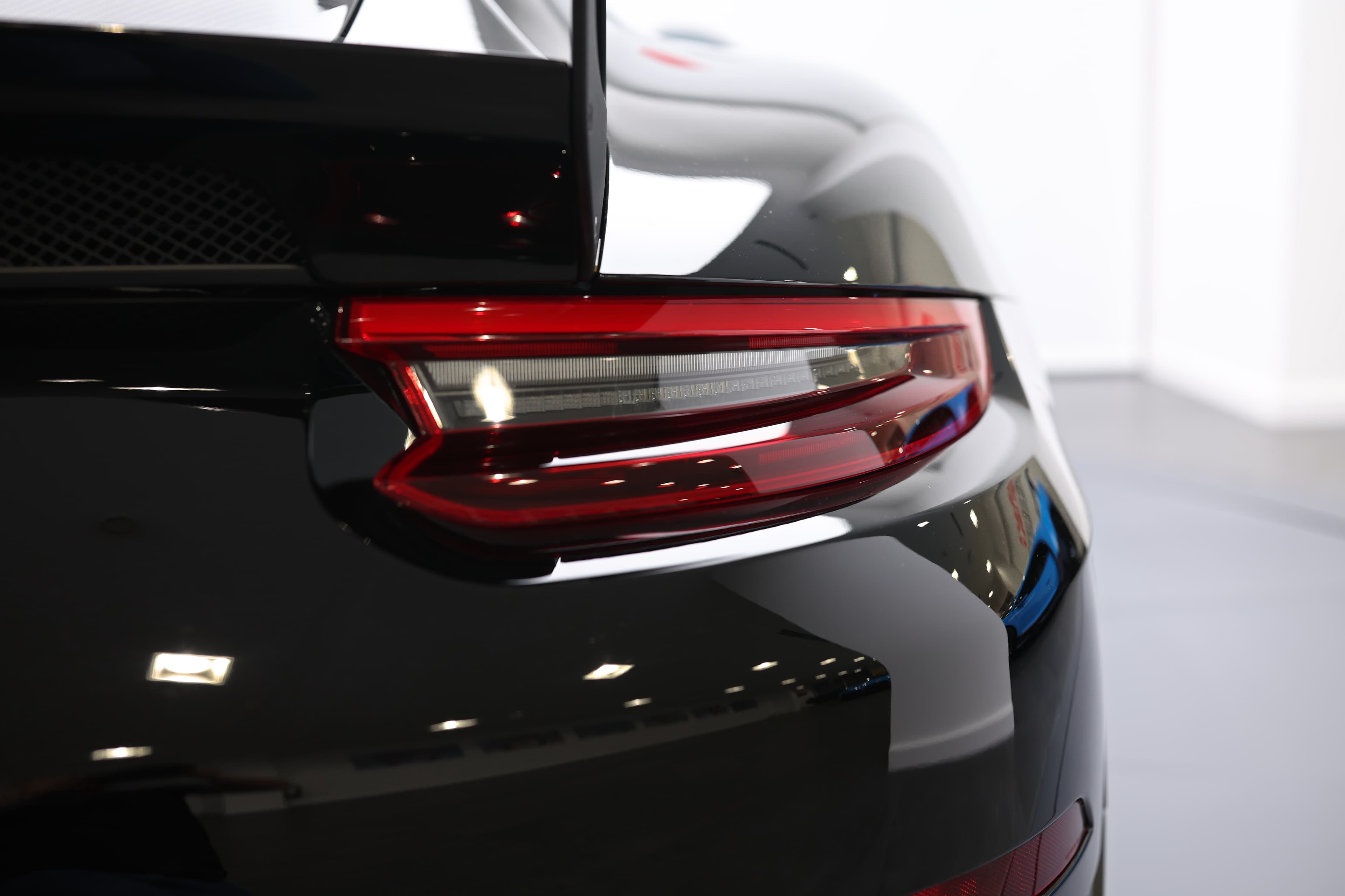 Image des feux arrière de la Porsche 911 GT2 RS noire, soulignant leur esthétique agressive et leur technologie LED avancée, ajoutant une touche de sophistication et d'agilité.
