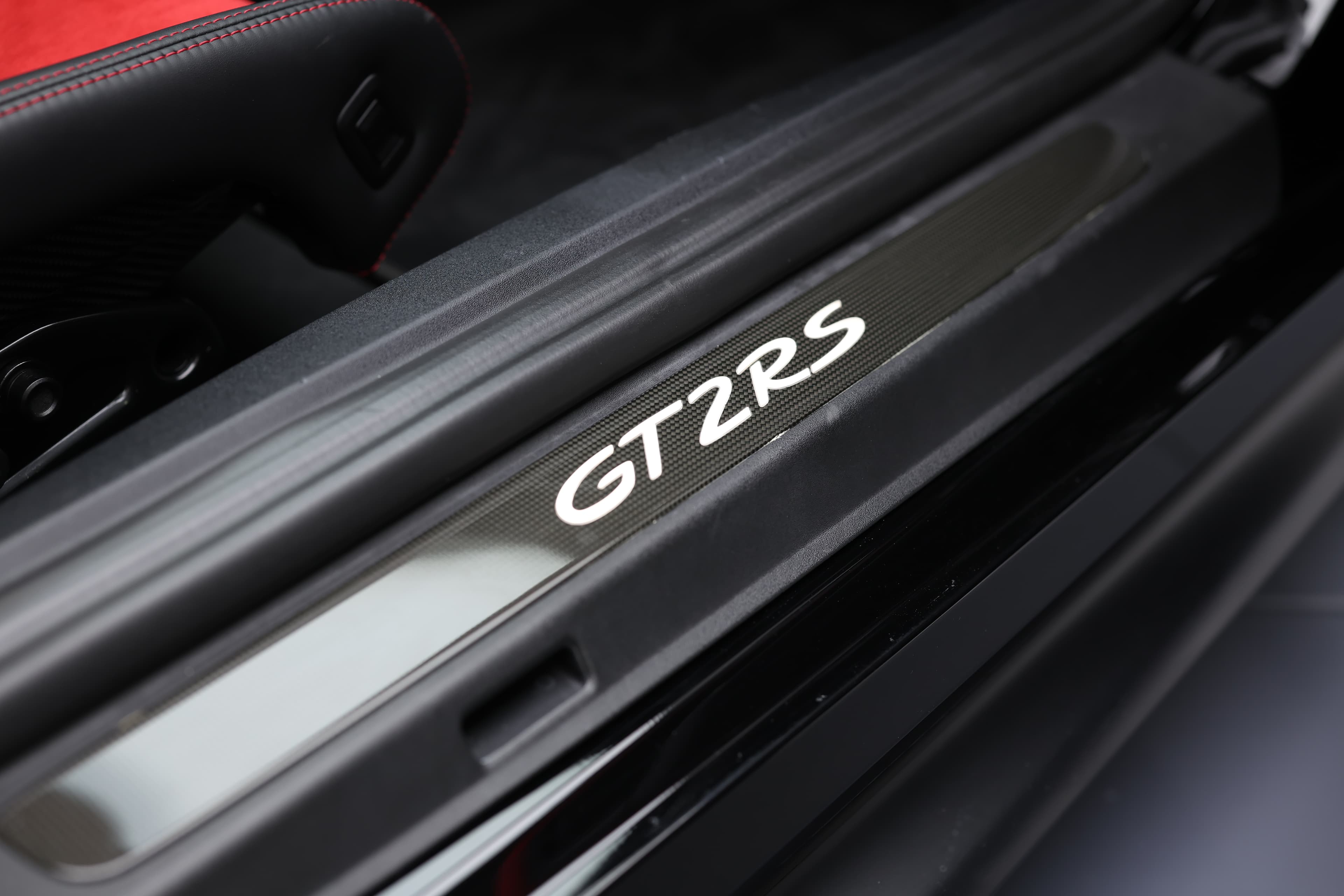 Photo du seuil de porte en carbone de la Porsche 911 GT2 RS, illustrant un mélange de légèreté et de robustesse, tout en ajoutant une touche de sophistication à l'intérieur de la supercar