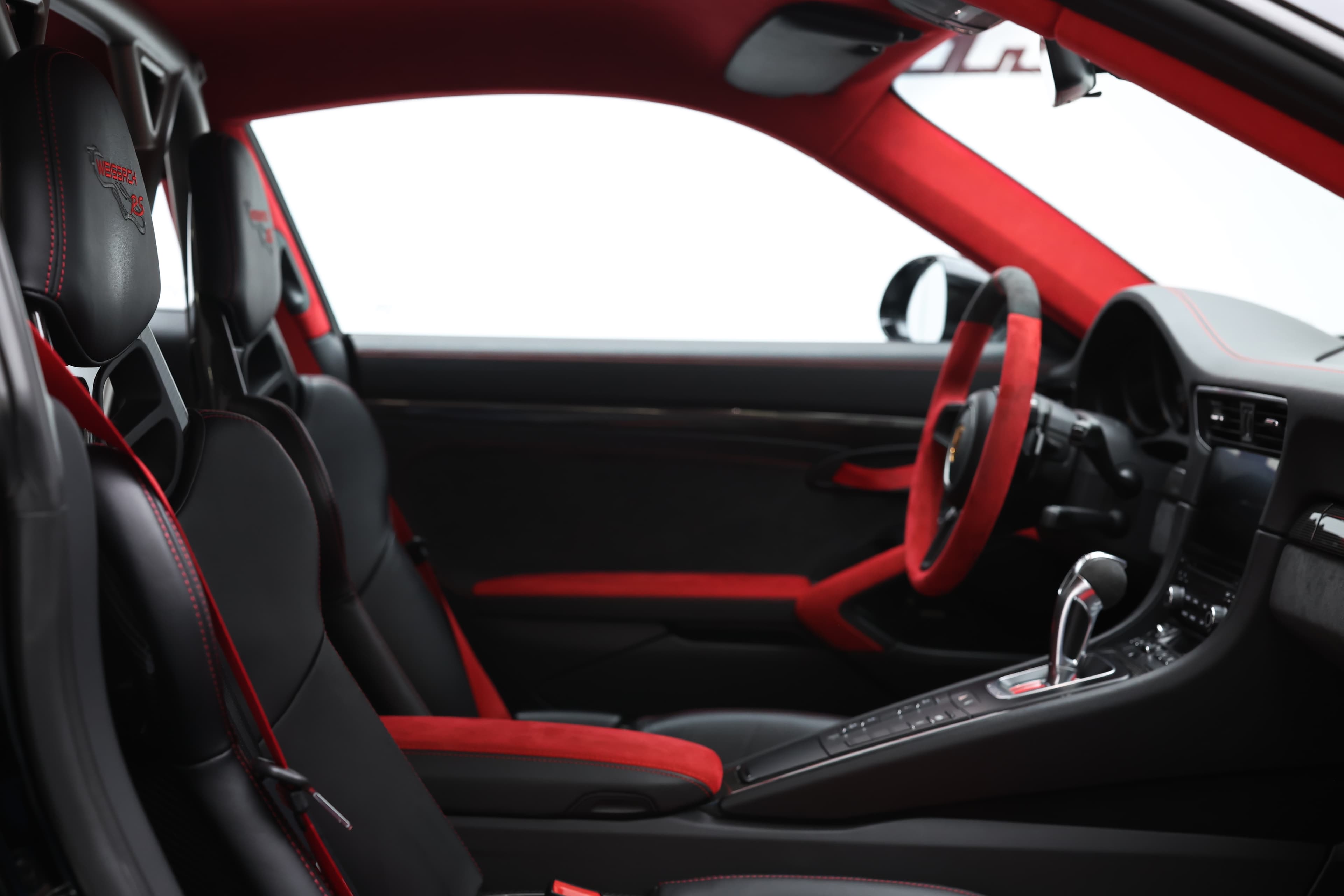 Photo de l'intérieur de la Porsche 911 GT2 RS vue du côté passager, mettant en avant le mélange de luxe, de sportivité et de technologies avancées.