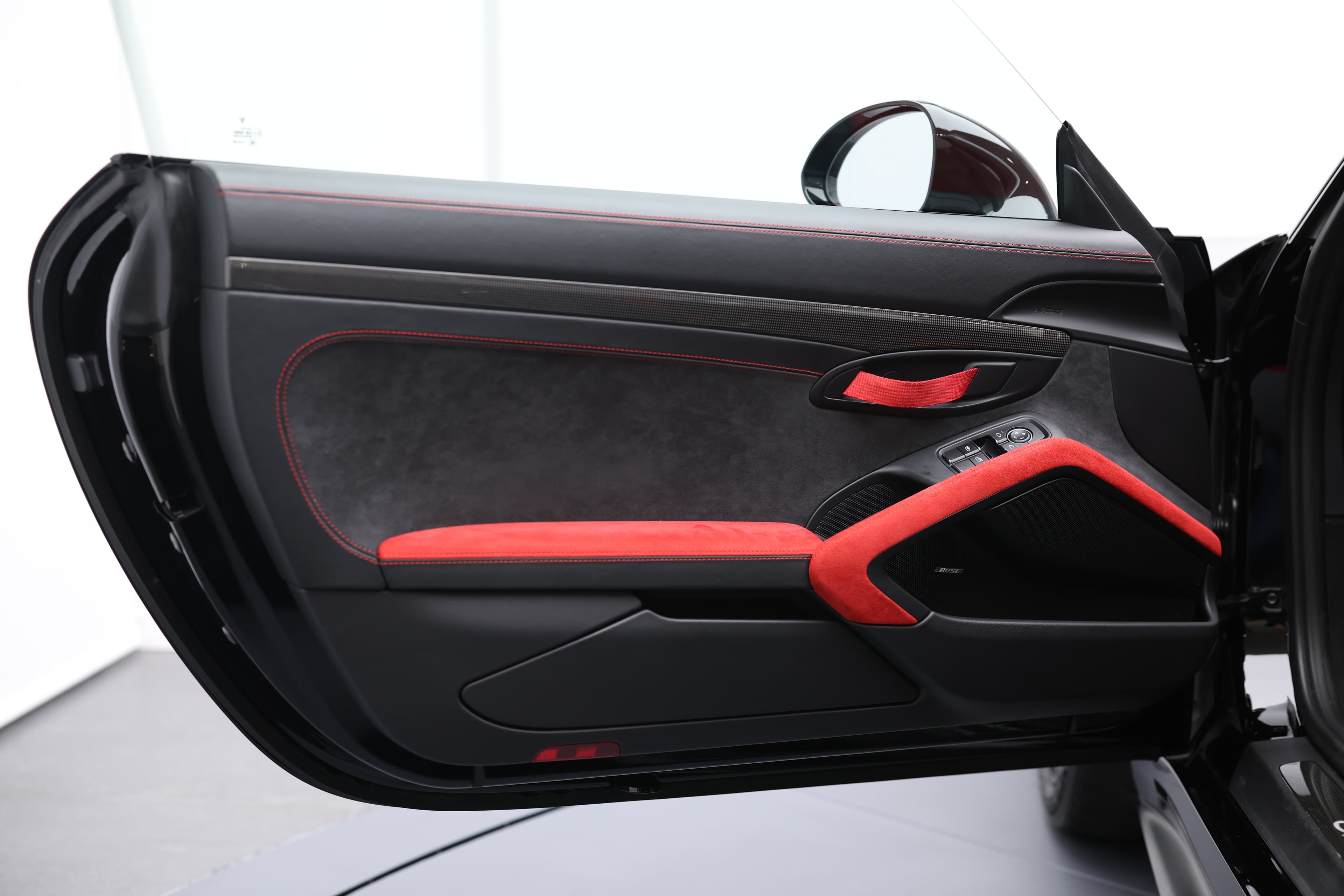 Photo de l'intérieur de la porte de la Porsche 911 GT2 RS, mettant en valeur les surpiqûres rouges qui ajoutent une touche de sportivité et d'élégance au design intérieur haut de gamme.