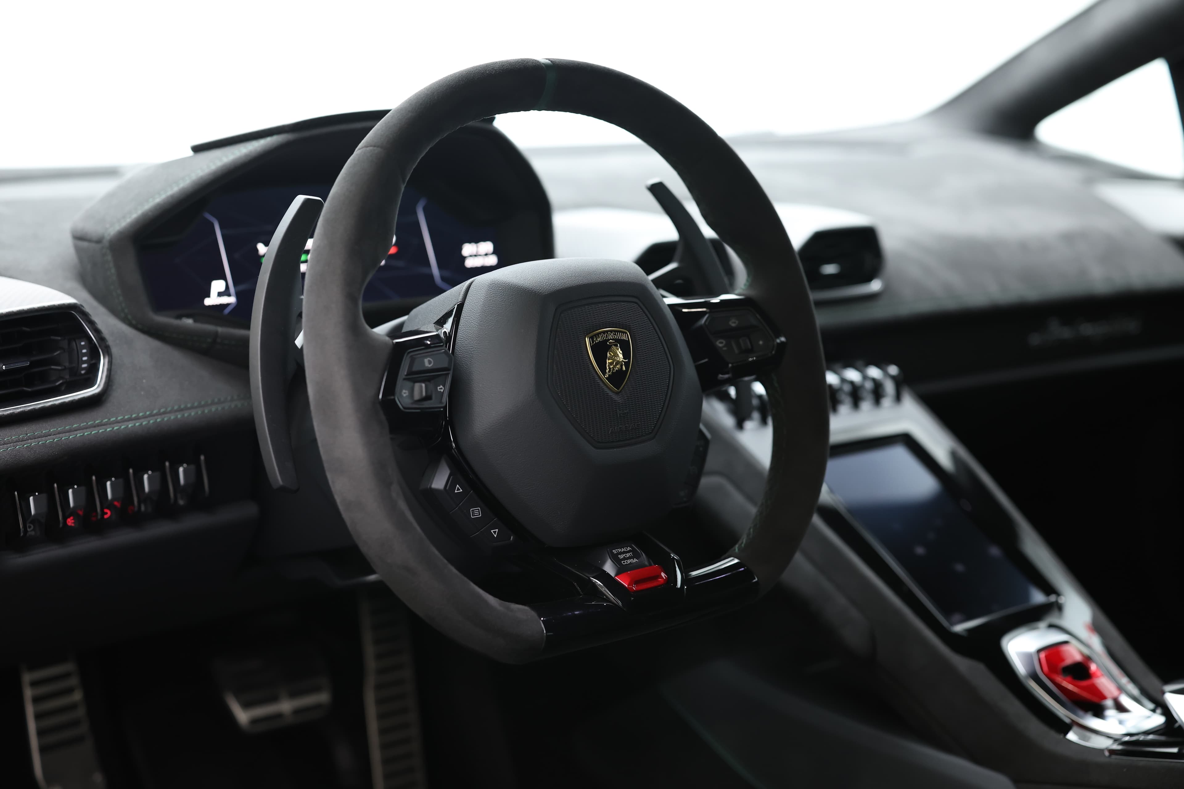 Le volant de la Lamborghini Huracán Tecnica, au design ergonomique et sportif, intègre des commandes intuitives, offrant au conducteur un contrôle optimal tout en ajoutant une touche de luxe à l'intérieur.