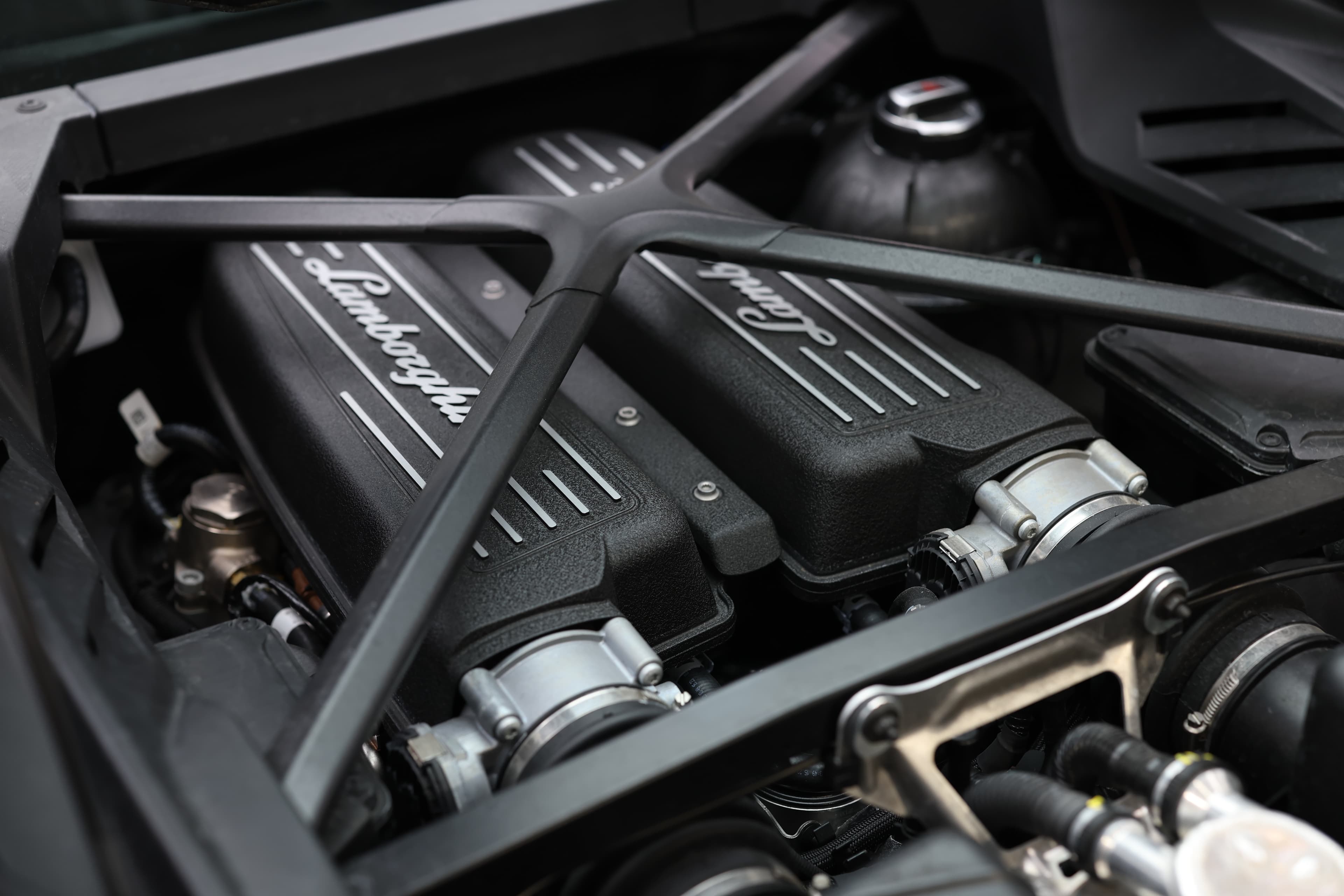 Le moteur de la Lamborghini Huracán Tecnica, visible à travers le capot arrière, révèle une ingénierie de pointe avec son design épuré et ses composants hautes performances, symbolisant la puissance brute de ce supercar.