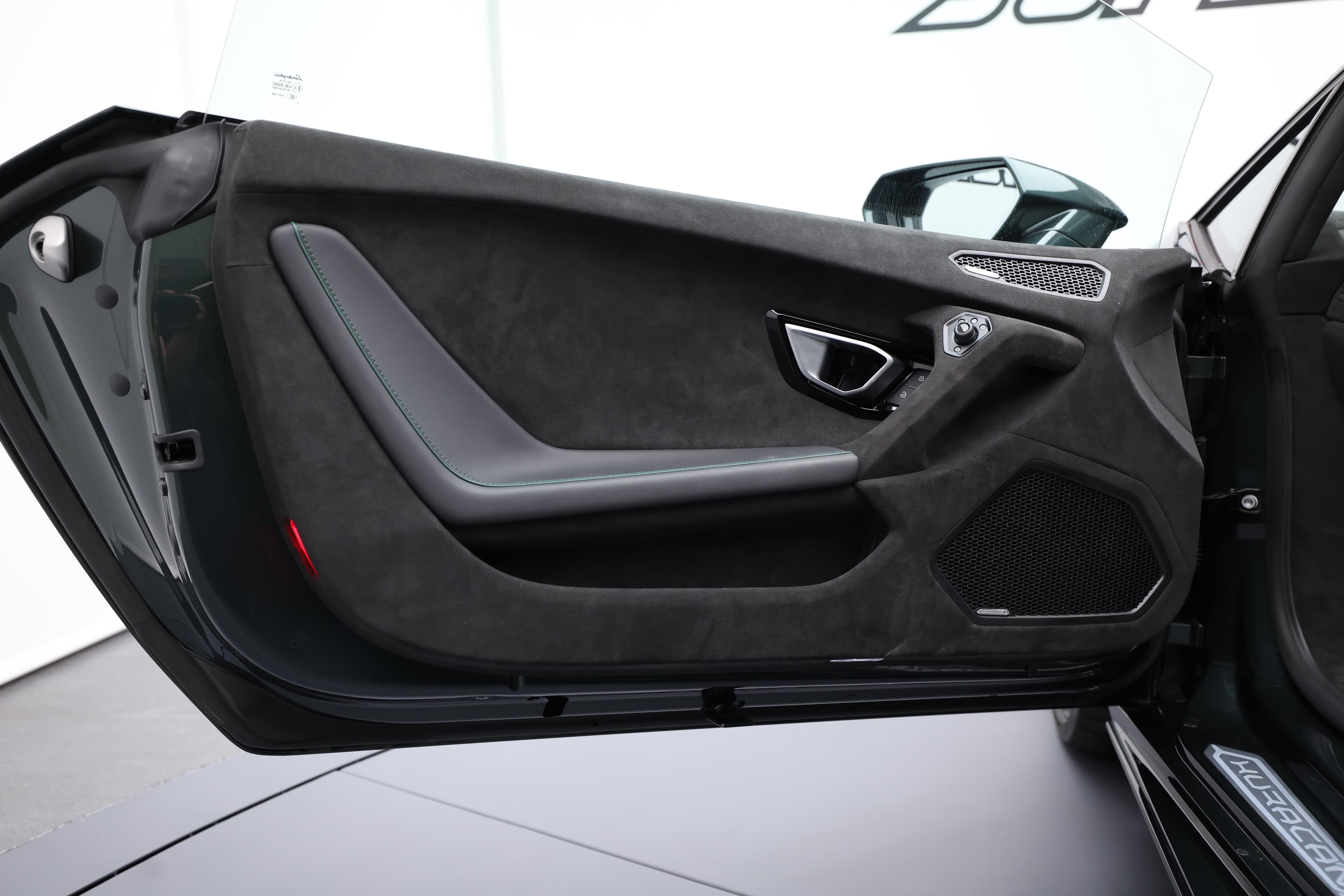 La porte de la Lamborghini Huracán Tecnica présente un design élégant avec des matériaux premium, intégrant des commandes intuitives et un éclairage d'ambiance sophistiqué pour une touche de luxe.