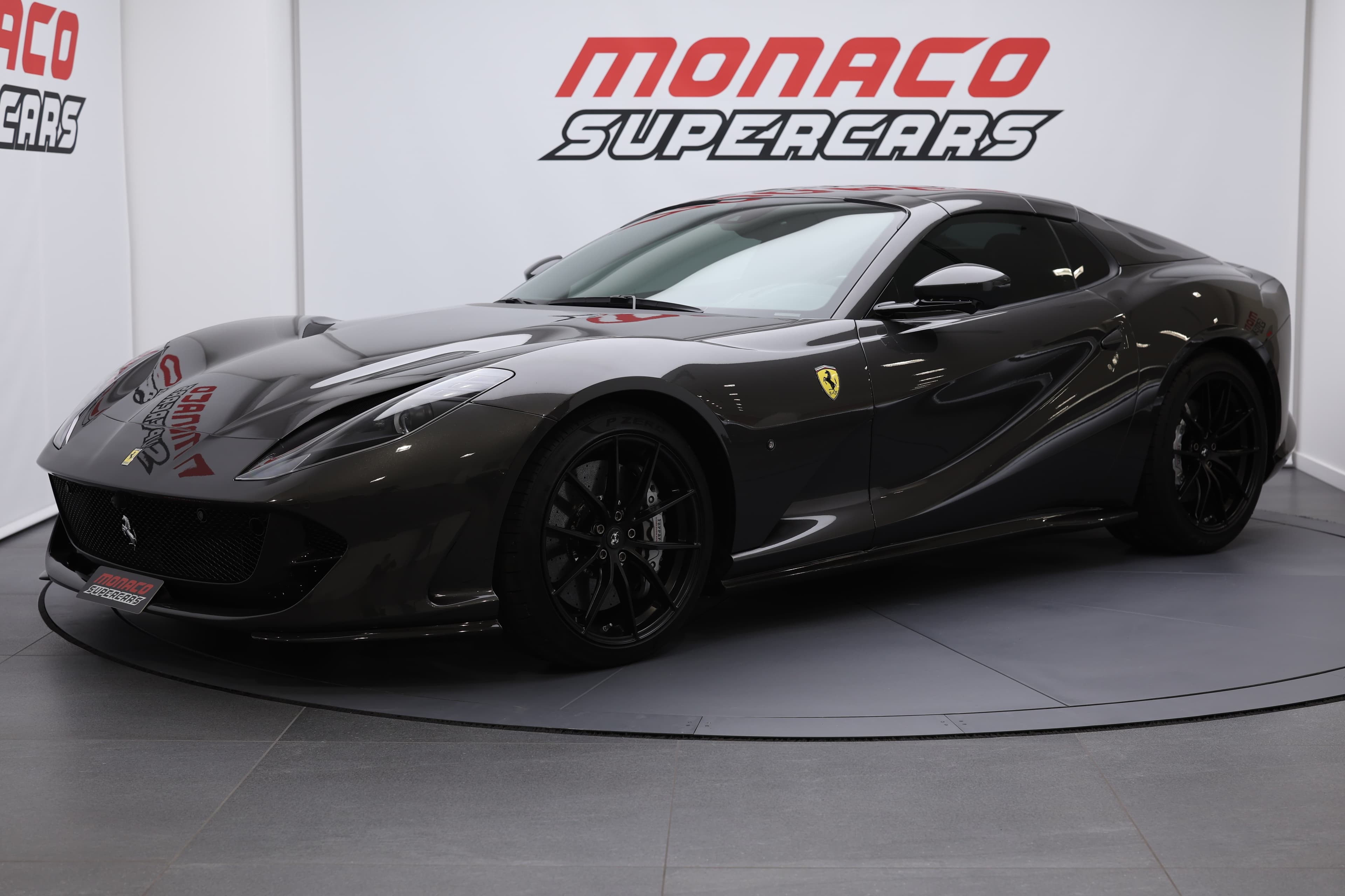 La photo montre une Ferrari 812 GTS vue de trois quarts avant, mettant en avant son capot sculpté et son toit élégant, symboles de performance et de luxe.