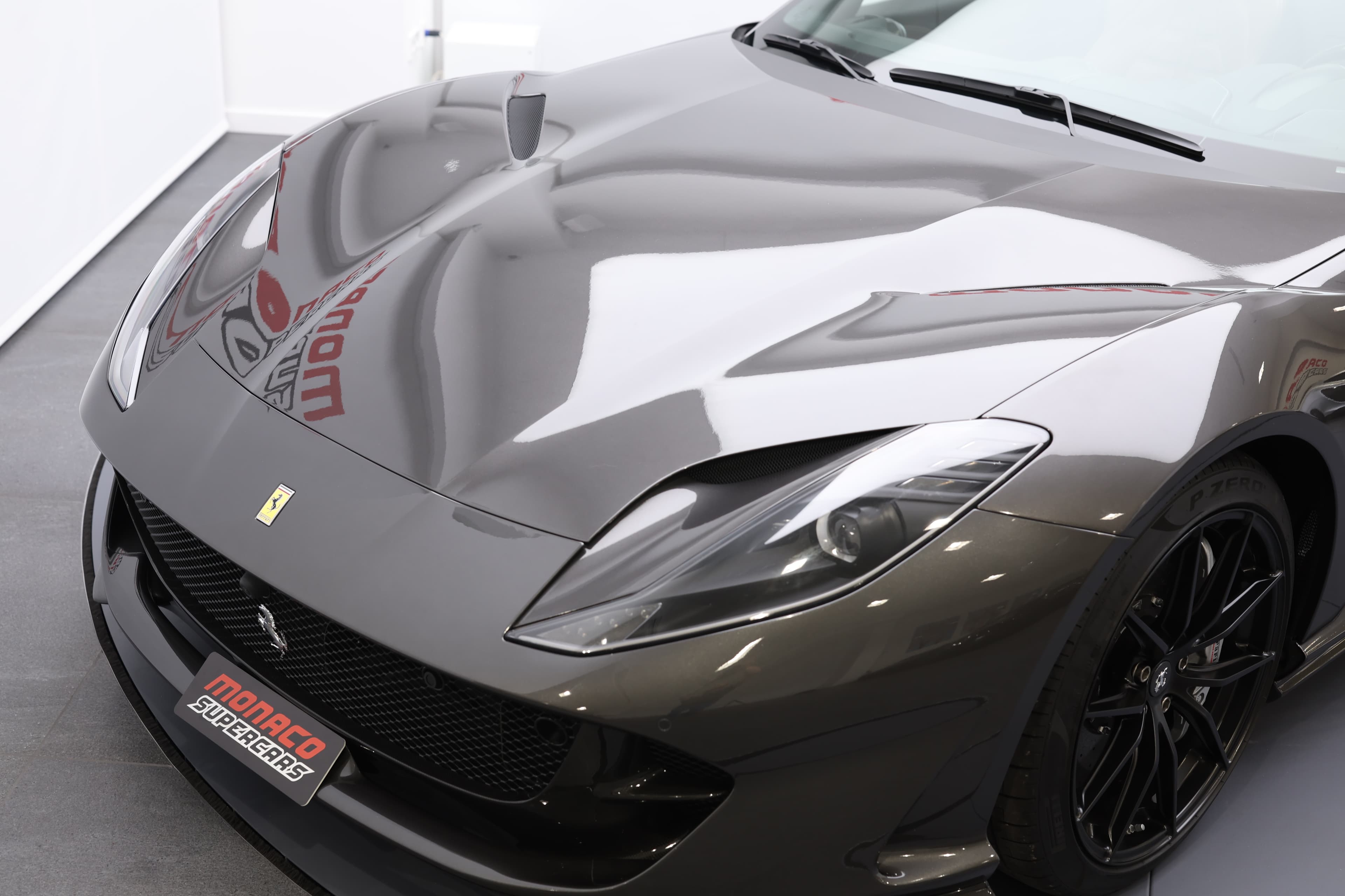 Le capot de la Ferrari 812 GTS, avec ses lignes fluides et sculptées, incarne la puissance et l'élégance de la voiture, tout en offrant un accès facile au moteur performant qui se cache en dessous.