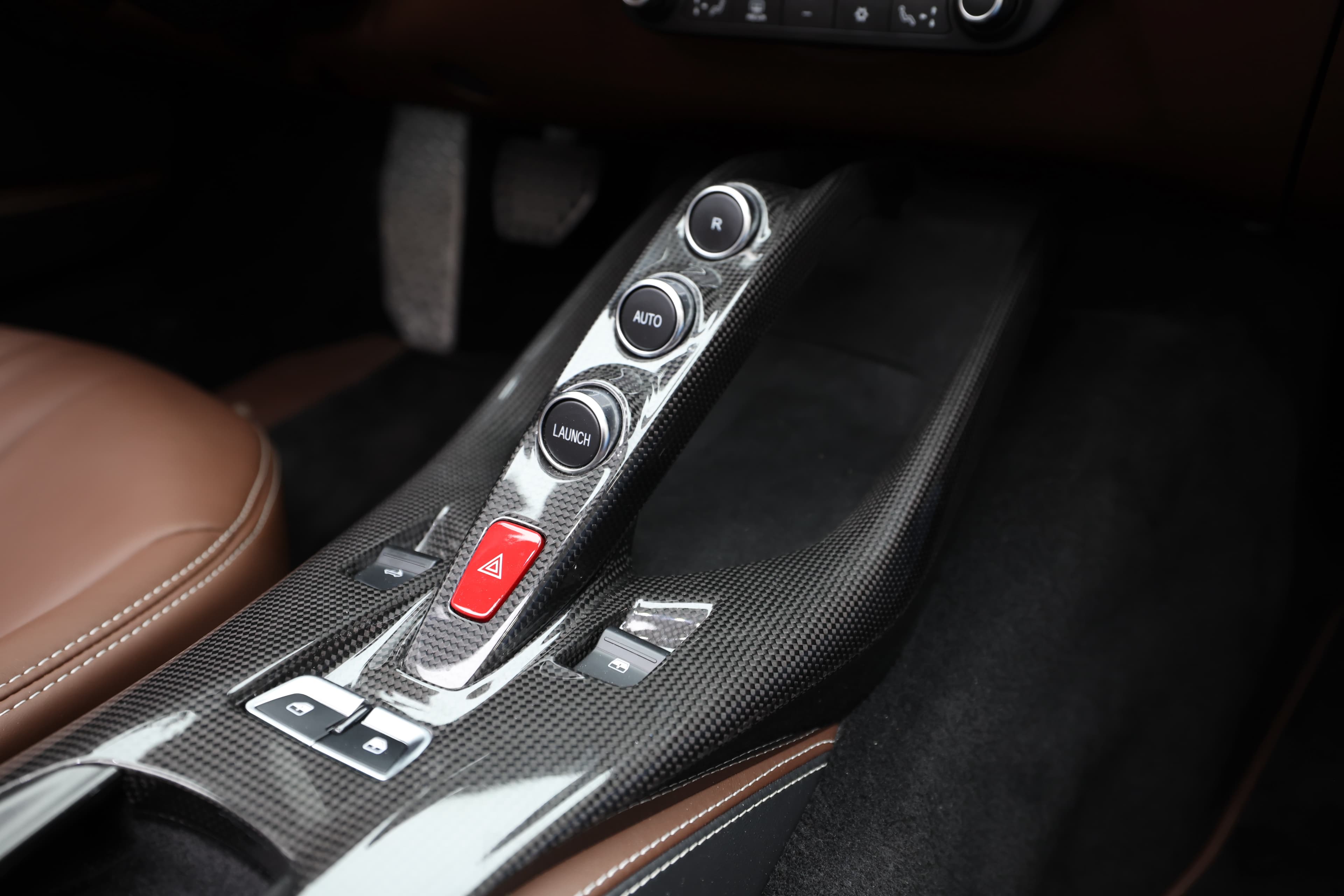Découvrez la console centrale en carbone de la Ferrari 812 GTS, qui abrite des commandes sophistiquées pour un accès facile aux fonctionnalités essentielles. Le mélange de matériaux haut de gamme et de design ergonomique reflète l'engagement de Ferrari envers le luxe et la performance, tout en créant une ambiance sportive et élégante.