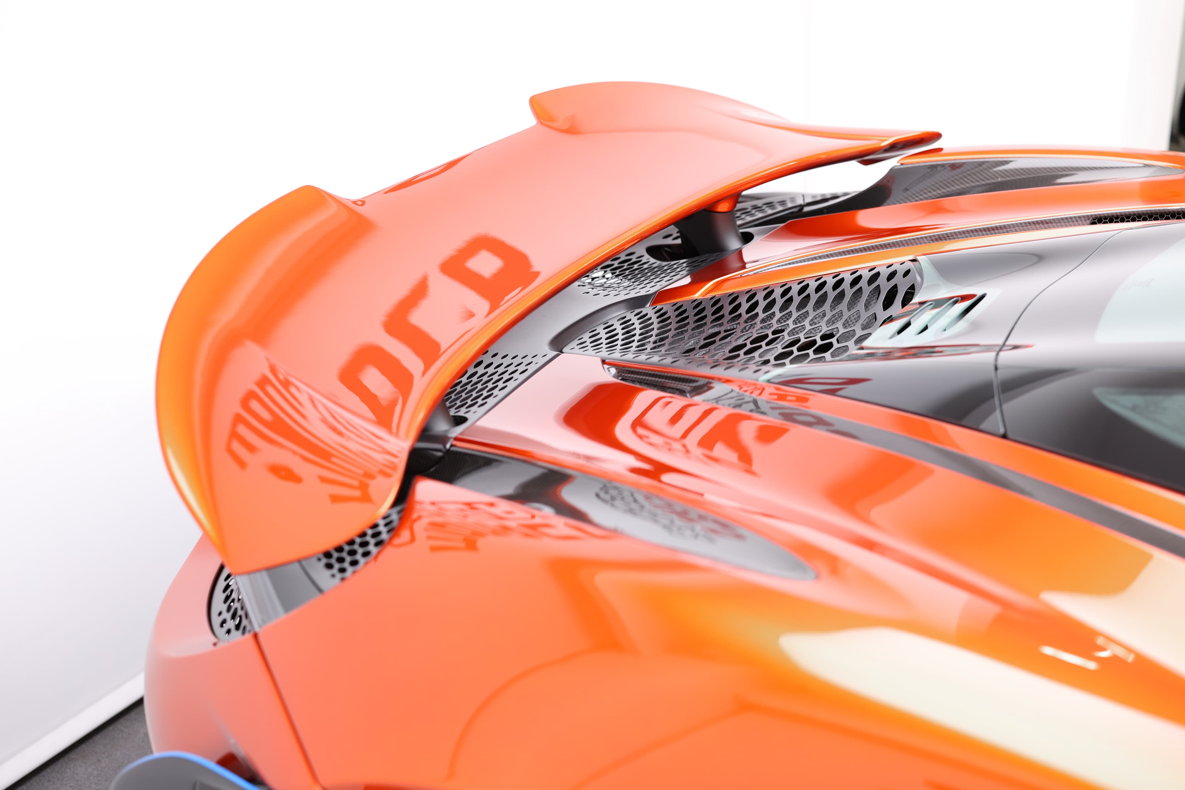 Gros plan sur l'aileron arrière de la McLaren 765LT, mettant en avant son design aérodynamique et les détails en carbone, illustrant l'importance de l'appui aérodynamique pour la performance de cette supercar.