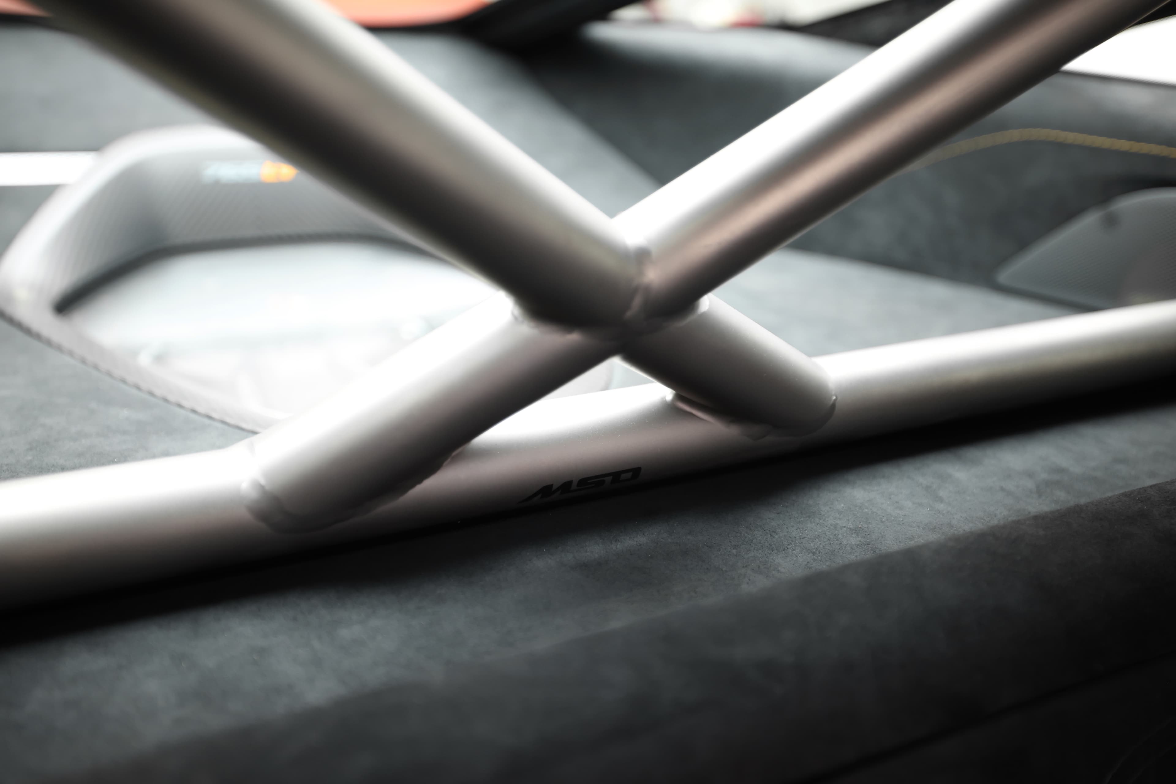 Gros plan sur l'arceau de la McLaren 765LT, mettant en avant la structure de sécurité et le design fonctionnel, soulignant l'engagement envers la performance et la sécurité sur circuit.