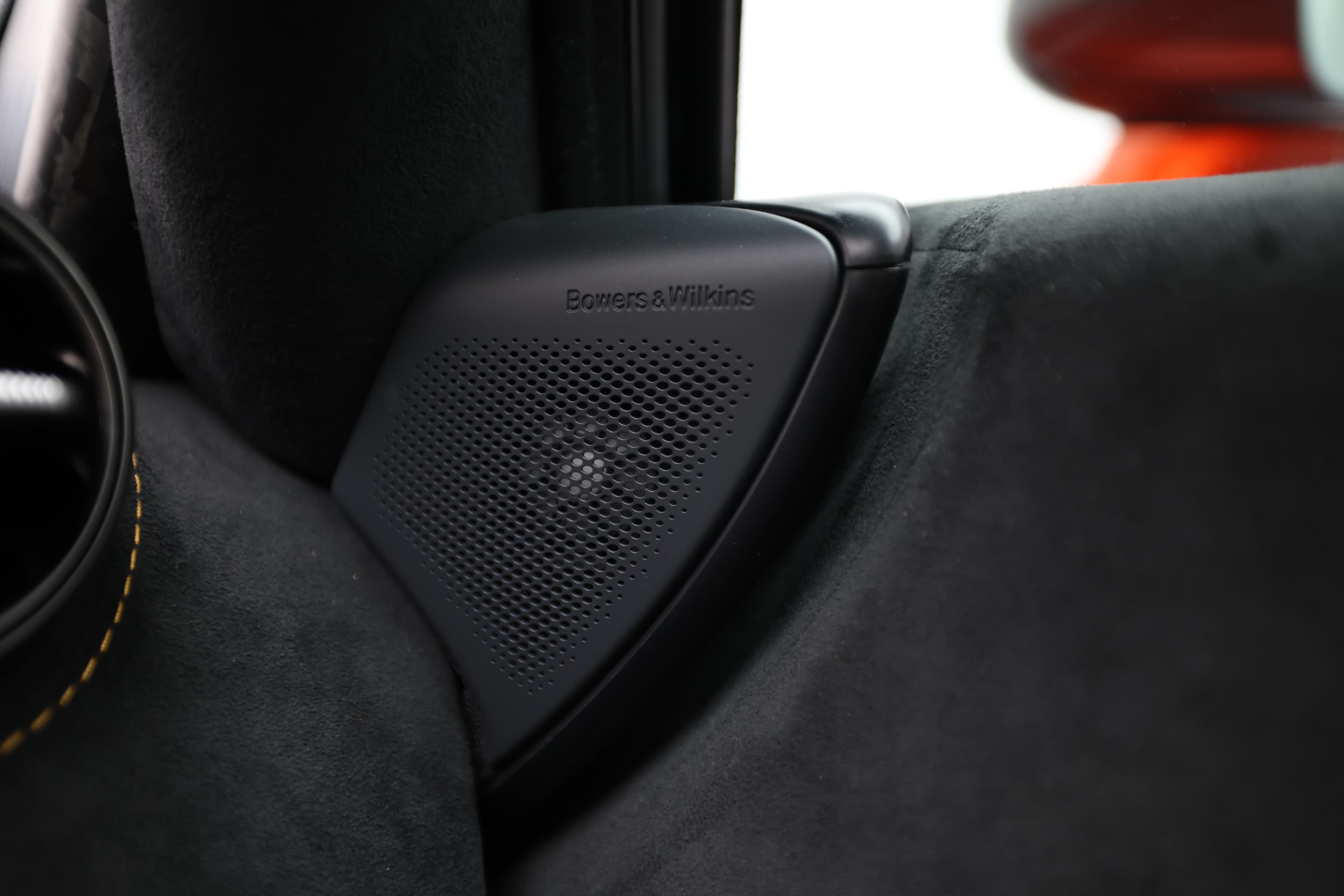 Gros plan sur le haut-parleur Bowers & Wilkins de la McLaren 765LT, mettant en avant la qualité audio supérieure et le design élégant, intégrés harmonieusement dans l'intérieur de la voiture.