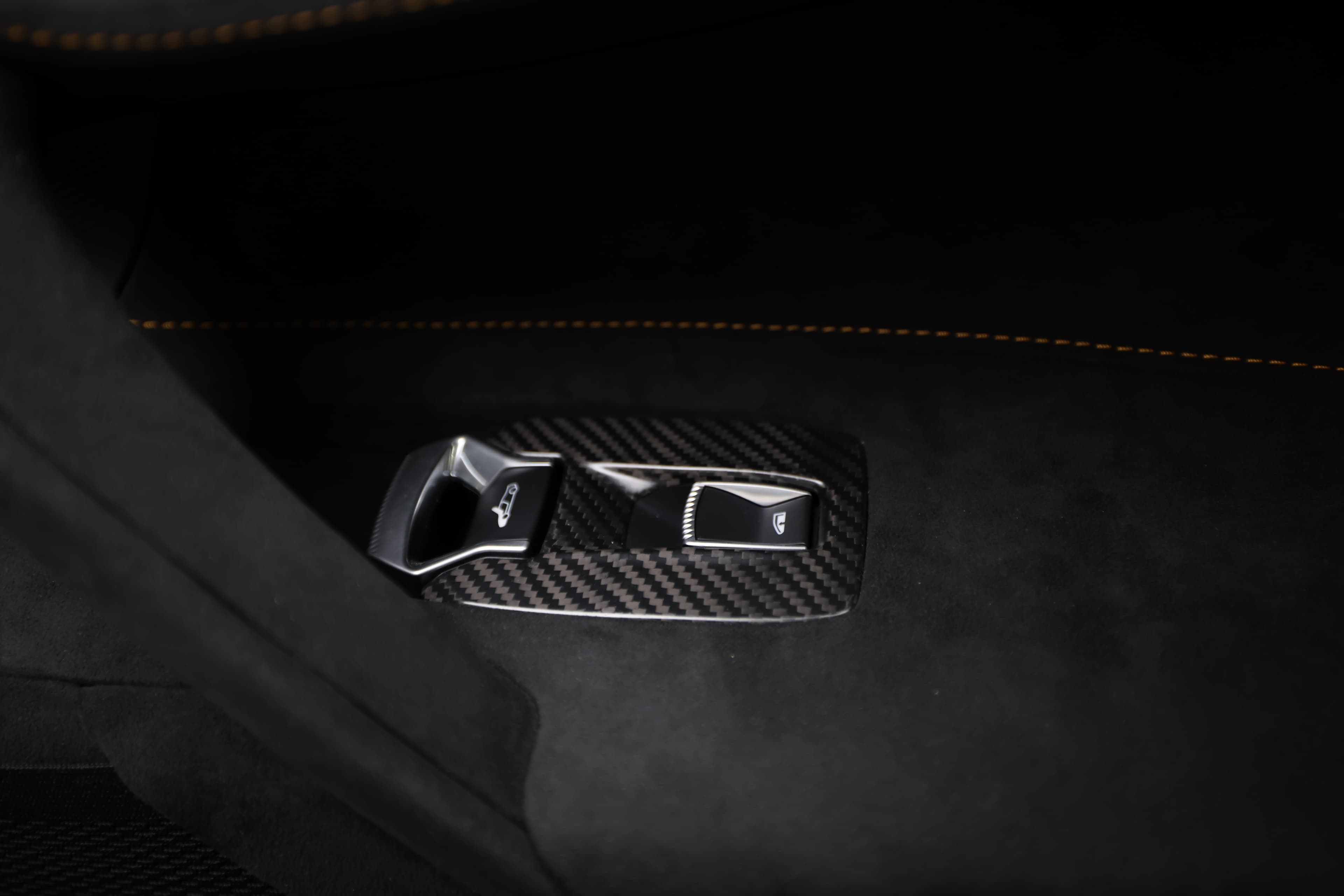 Gros plan sur les detail en carbone de la McLaren 765LT, mettant en avant le mélange de légèreté et de robustesse, tout en soulignant l'attention portée aux détails dans l'habitacle.