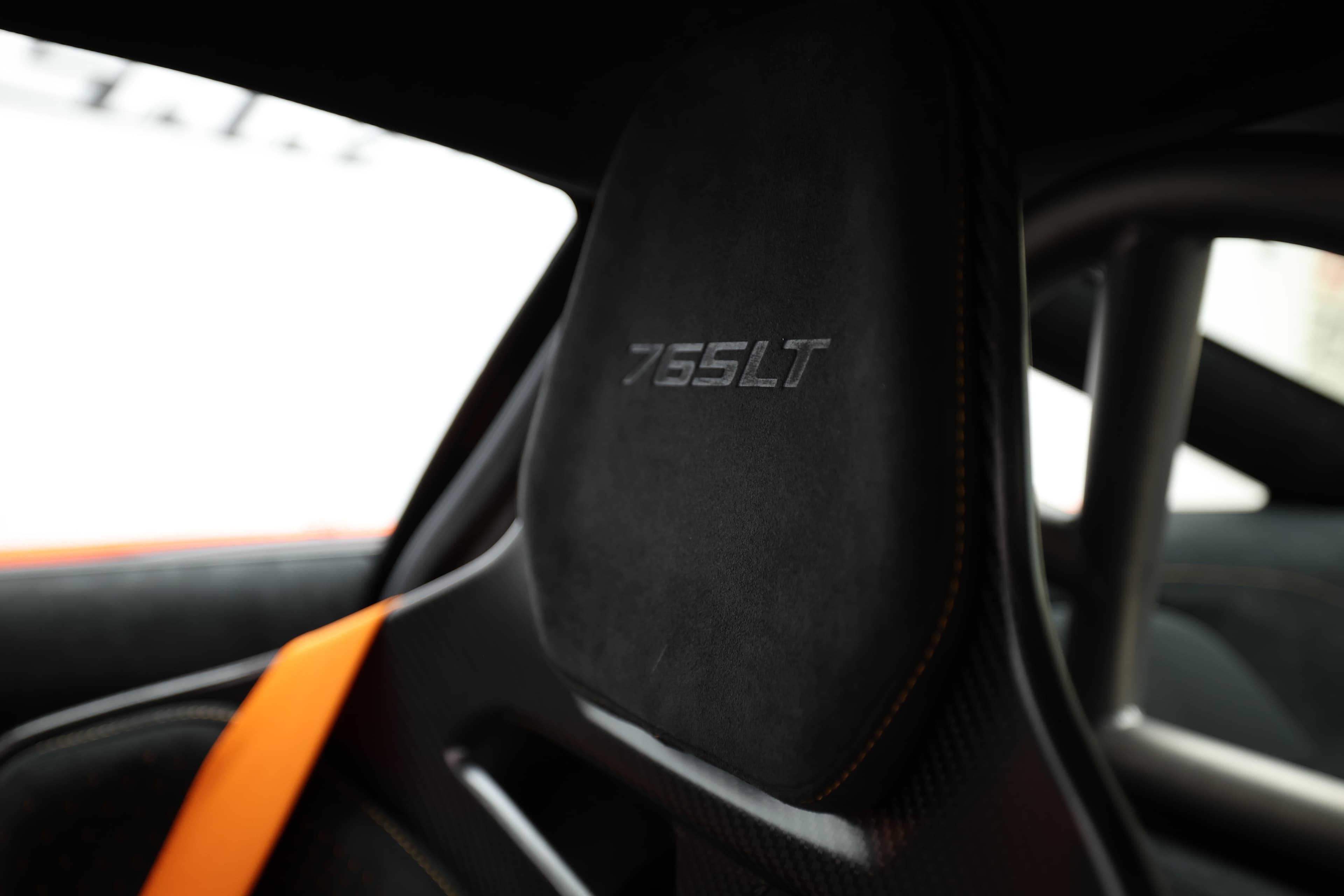 Gros plan sur le siège de la McLaren 765LT, mettant en avant le logo '765LT' brodé, symbolisant l'exclusivité et la performance de ce modèle haut de gamme.