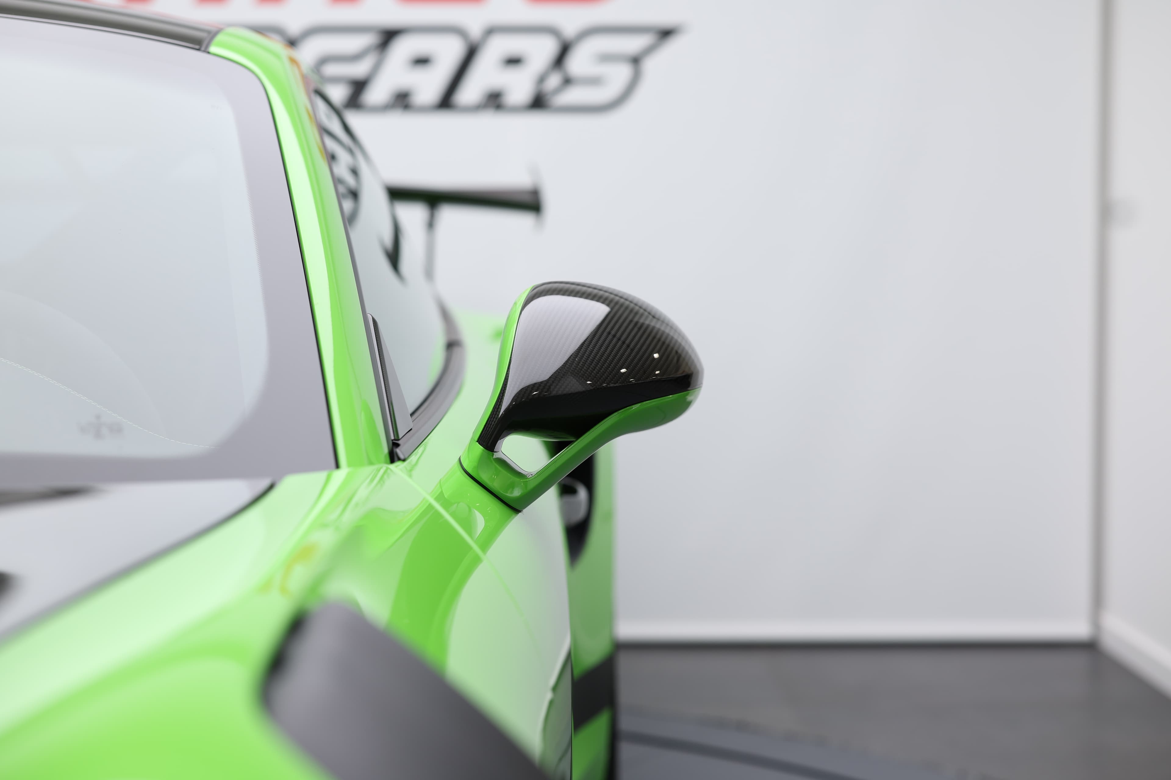 Détail de la Porsche 911 GT3 RS 991 verte mettant en valeur le rétroviseur sport et les lignes aérodynamiques affûtées, symbole d’un design radical orienté performance.