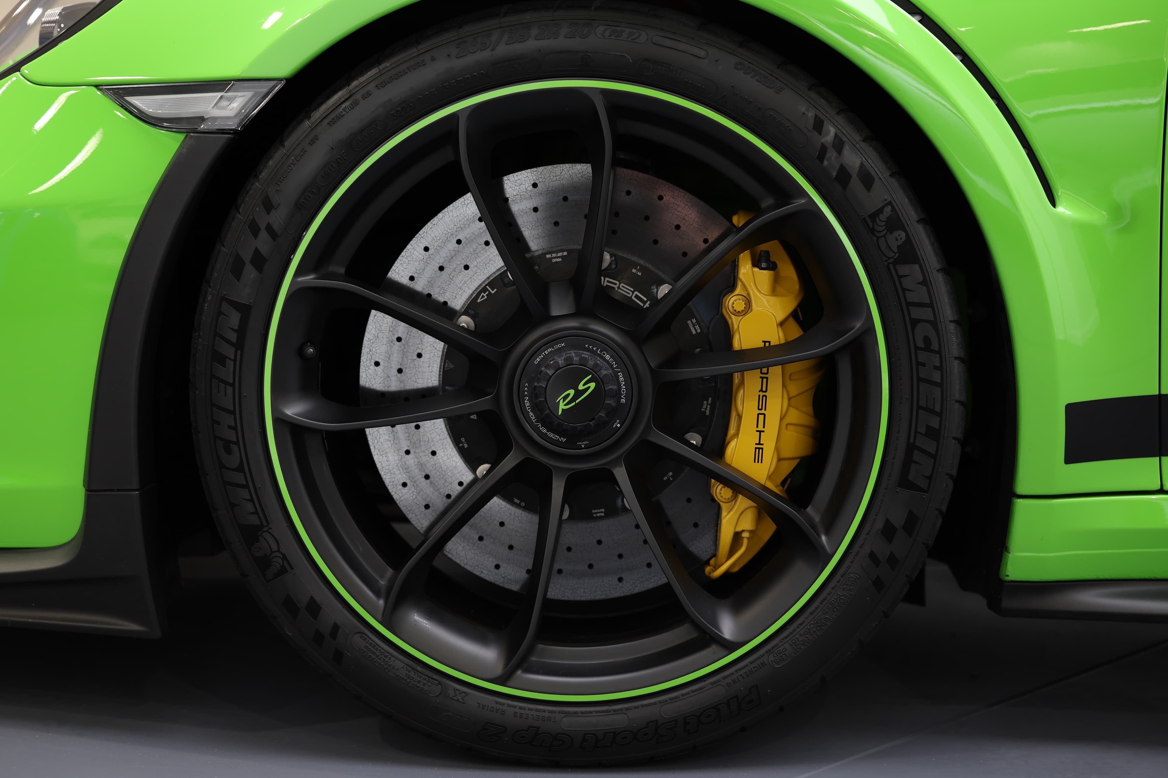 Détail de la roue de la Porsche 911 GT3 RS 991 verte avec jante centrale, freins carbone-céramique et étrier jaune, illustrant son équipement hautes performances orienté circuit.
