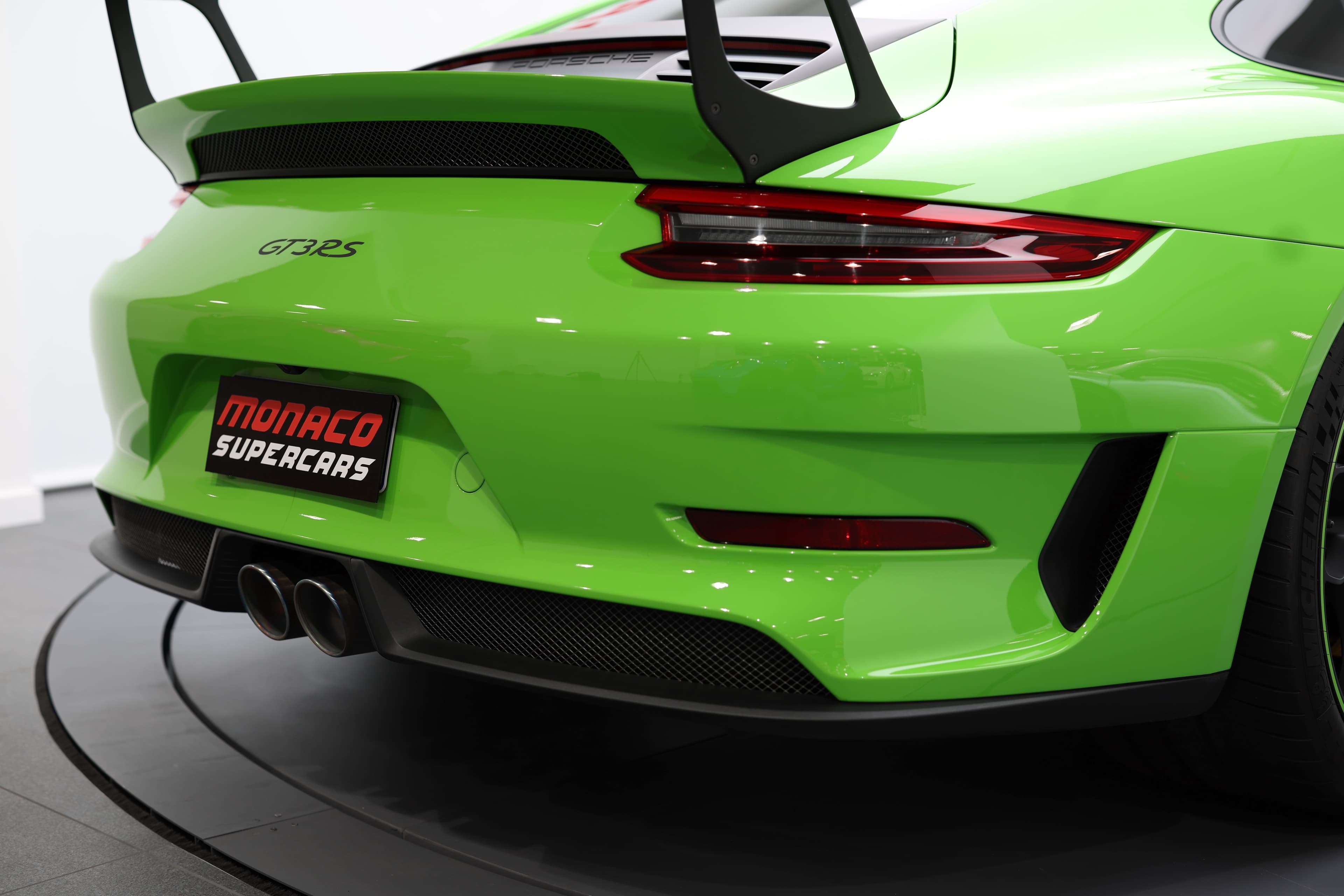 Vue arrière de la Porsche 911 GT3 RS (991) verte, soulignant le large diffuseur, les sorties d’échappement centrales, les feux arrière affinés et l’aileron fixe imposant, avec l’inscription GT3 RS confirmant son ADN radical orienté piste.