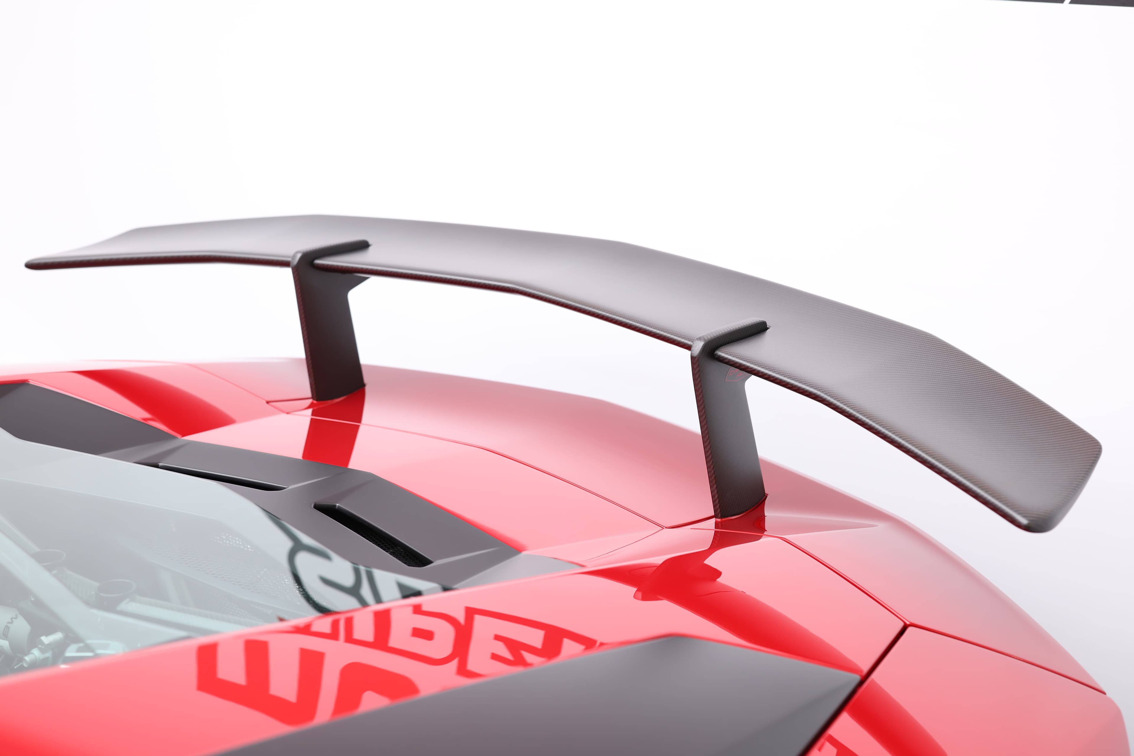 Approchez-vous de l'aileron arrière de la Lamborghini Aventador SV, conçu pour maximiser l'appui aérodynamique à grande vitesse, tout en ajoutant une esthétique résolument sportive.