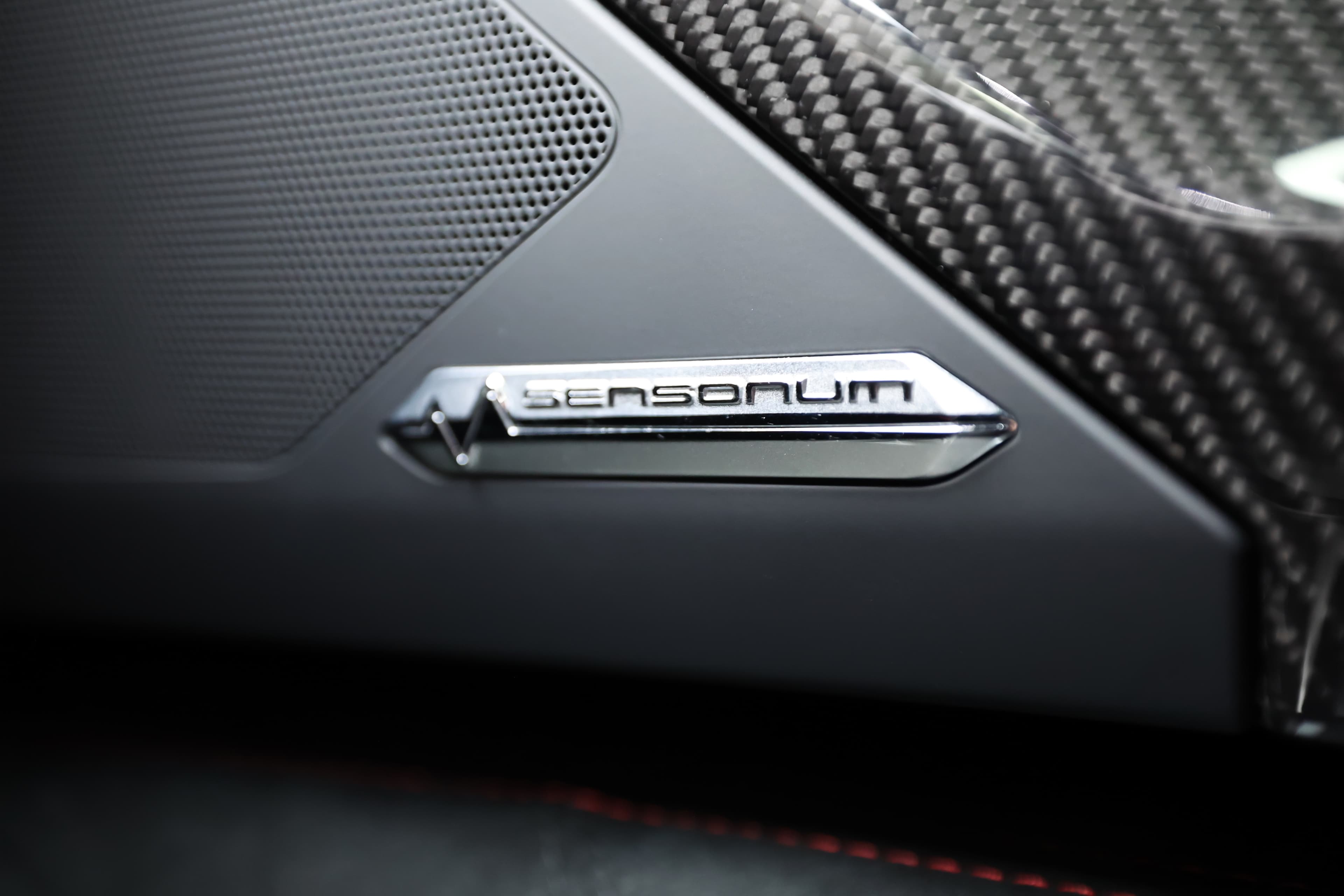 Détail du badge 'Sensonium' sur le système audio de la Lamborghini Aventador SV. Ce logo souligne la qualité du son et la technologie de pointe intégrées, offrant une expérience audio immersive qui complète le luxe et la performance de ce véhicule d'exception.