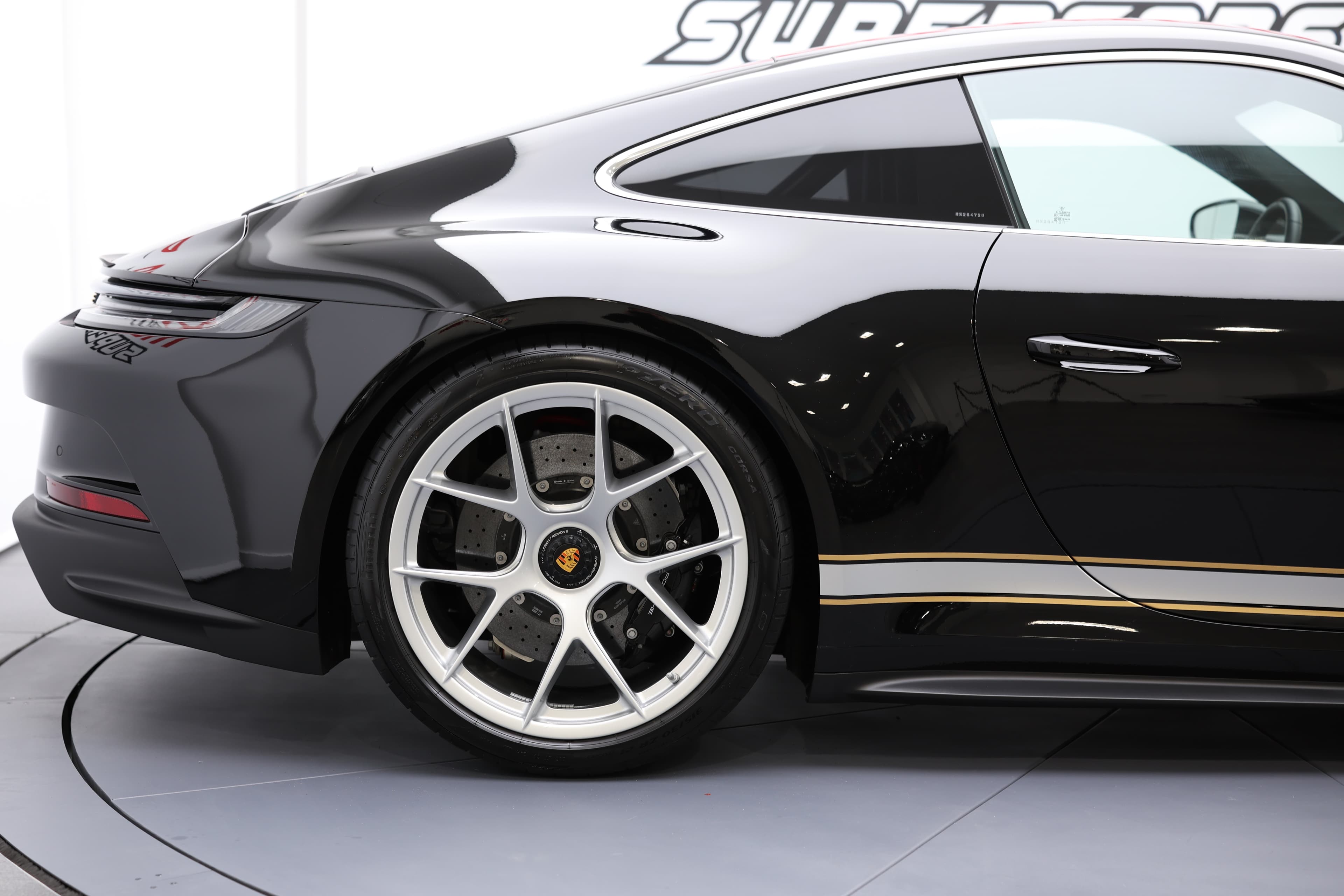 Vue latérale de la Porsche 911, mettant en avant le design dynamique de la carrosserie et les jantes sportives, accentuant son caractère unique et ses performances de haut niveau.