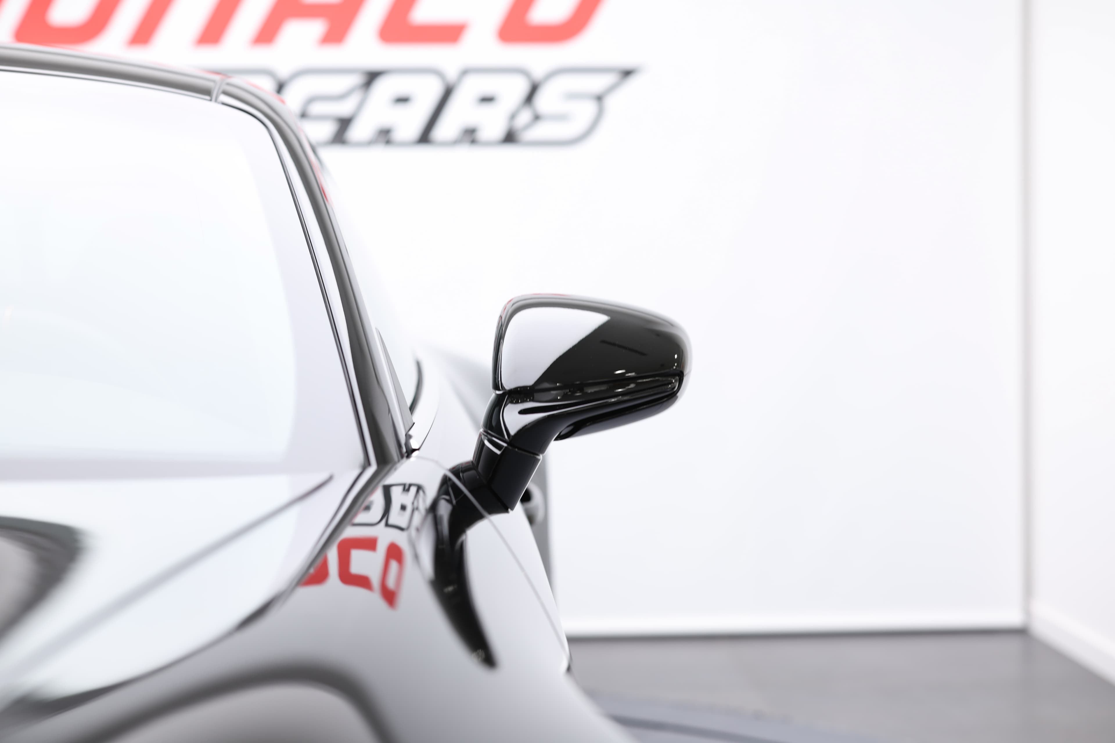 Détail du rétroviseur de la Porsche 911, illustrant l'aérodynamisme et le style raffiné de ce modèle, tout en ajoutant une touche sportive à l'ensemble.