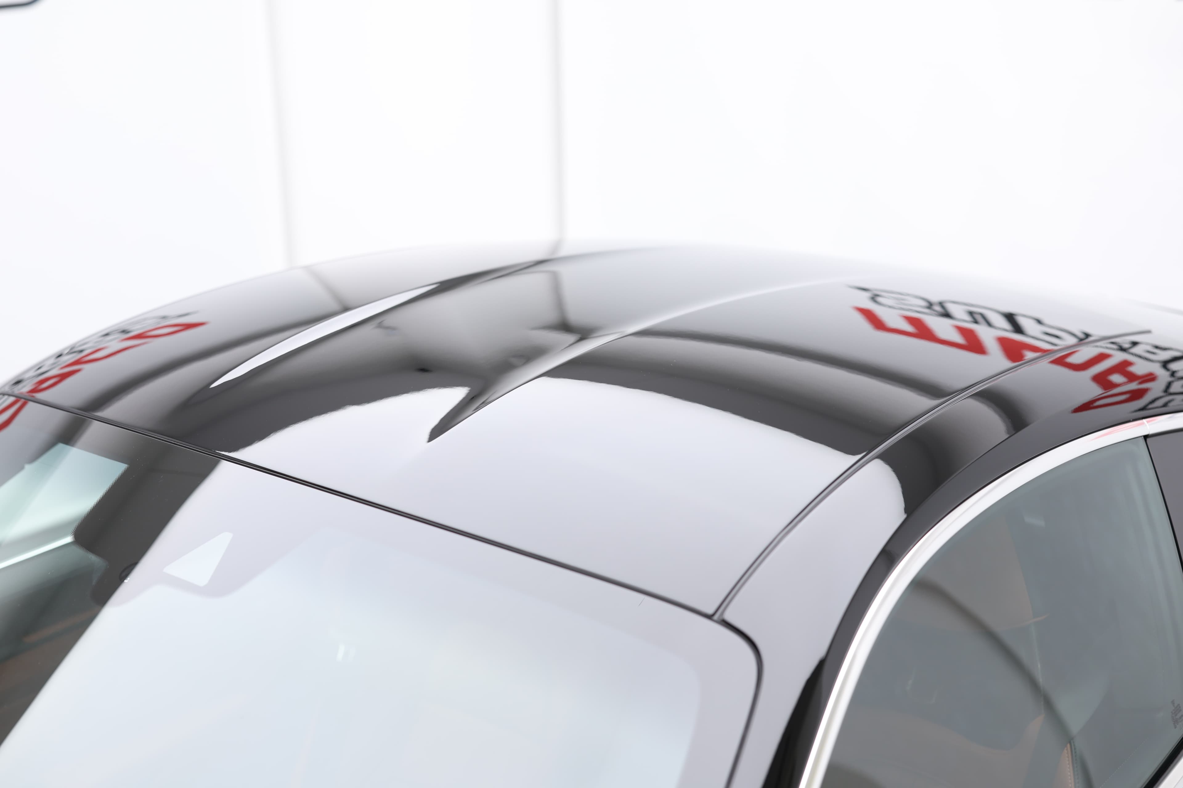 Détail du toit de la Porsche 911, révélant les lignes fluides et un aileron qui contribue à l'aérodynamisme, tout en renforçant l'identité sportive du véhicule, un vrai symbole de performance sur route.