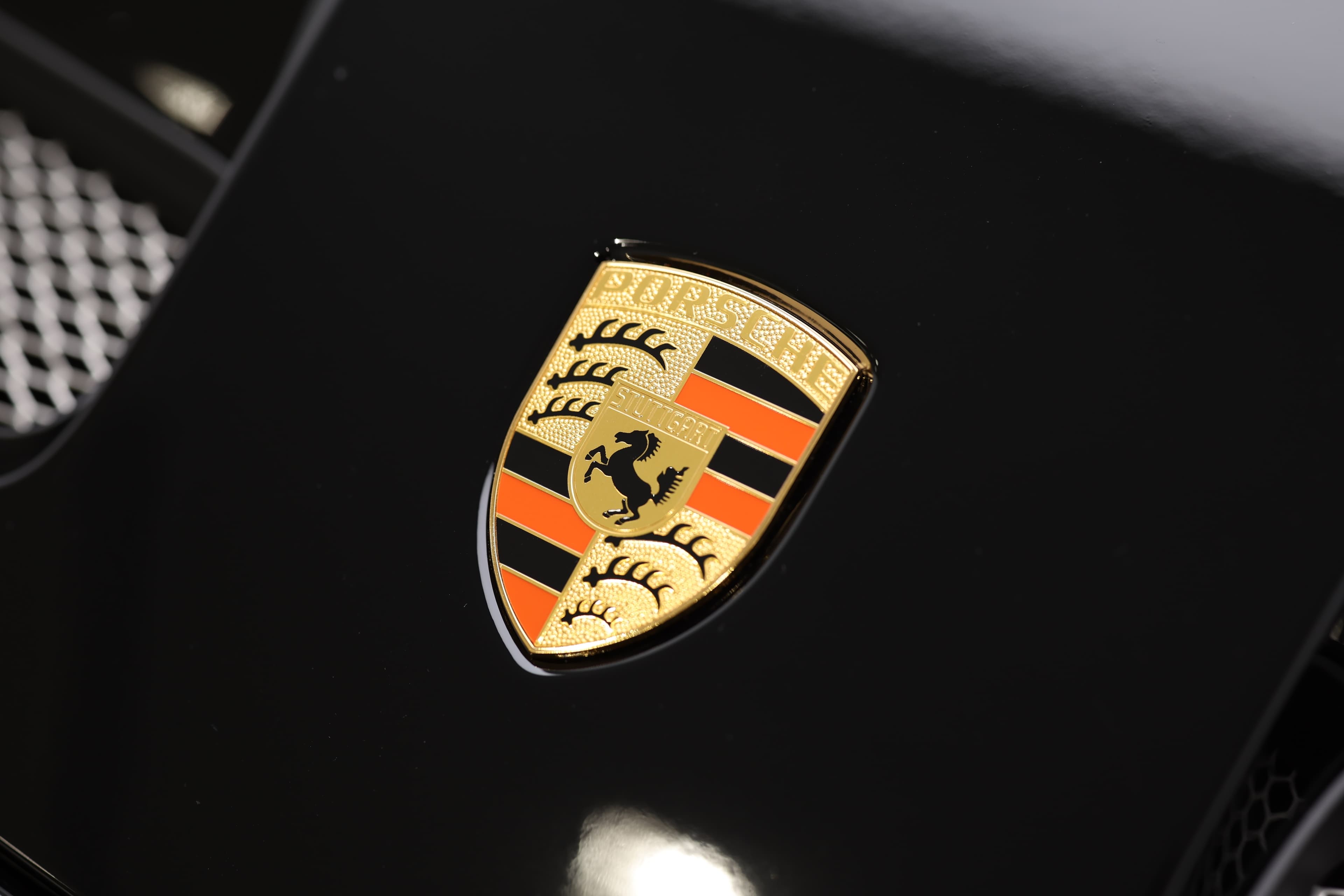 Gros plan sur le logo emblématique de Porsche, qui incarne l'héritage et la performance de la marque. Ce blason, avec ses couleurs vibrantes et son design distinctif, est synonyme de luxe et de sportivité, représentant l'excellence automobile et la passion pour la conduite.
