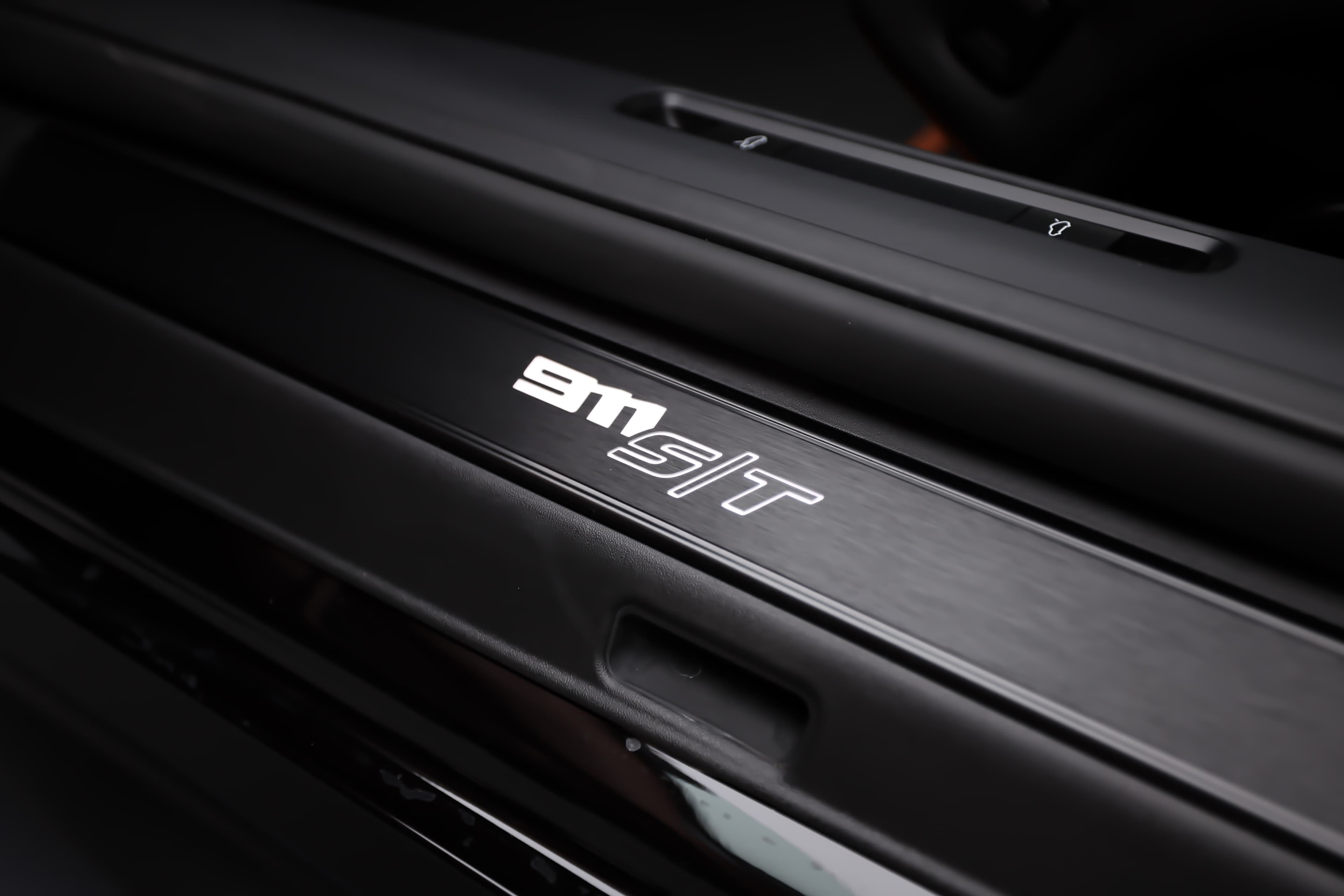 Découvrez le badge distinctif "9M ST" sur un tableau de bord moderne, alliant design et performance.