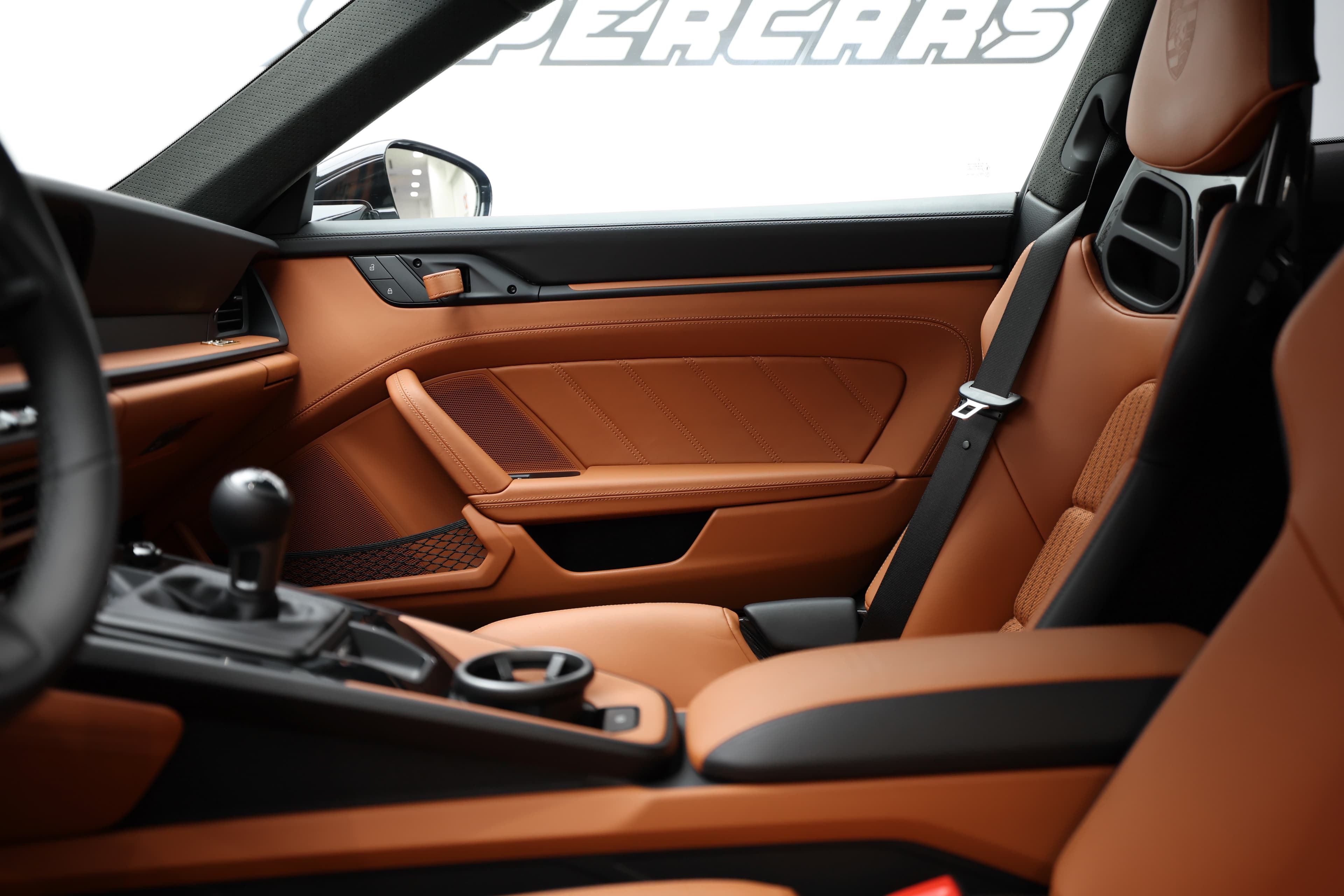 Admirez l'intérieur élégant d'une voiture de sport, mettant en avant des sièges en cuir orange et un design moderne, alliant confort et performance.