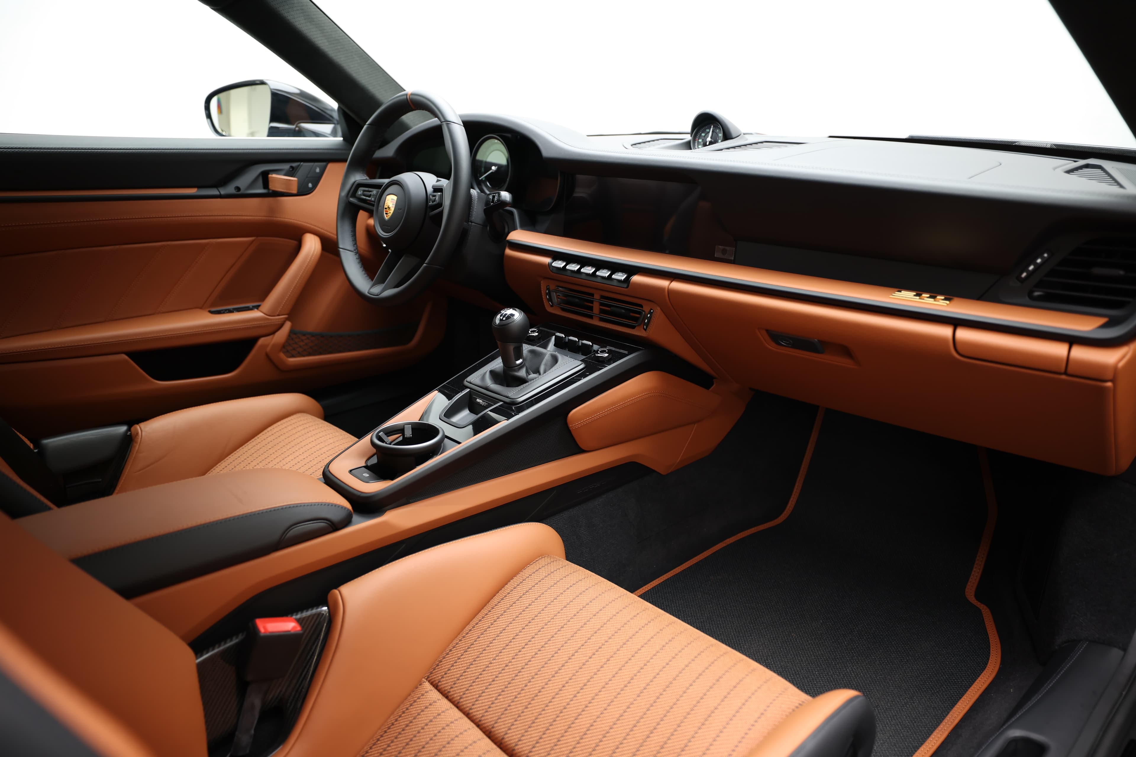 Un habitacle spacieux et raffiné, combinant des sièges en cuir orange, un tableau de bord moderne et des commandes intuitives, créant une atmosphère de luxe et de performance exceptionnelle pour chaque trajet.